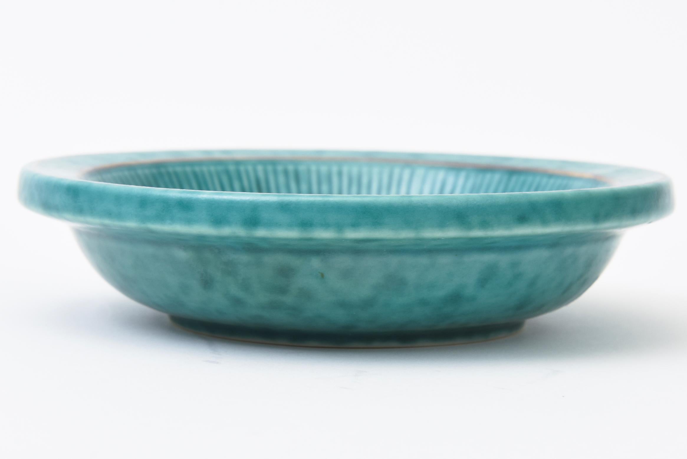 This lovely vintage mid century modern ceramic turquoise green stoneware bowl has applied designs of sterling silver flowers and leafs  and was designed by Wilhelm Kage for Gustavsberg Sweden. Hallmarked on the bottom in the stoneware and a label.
