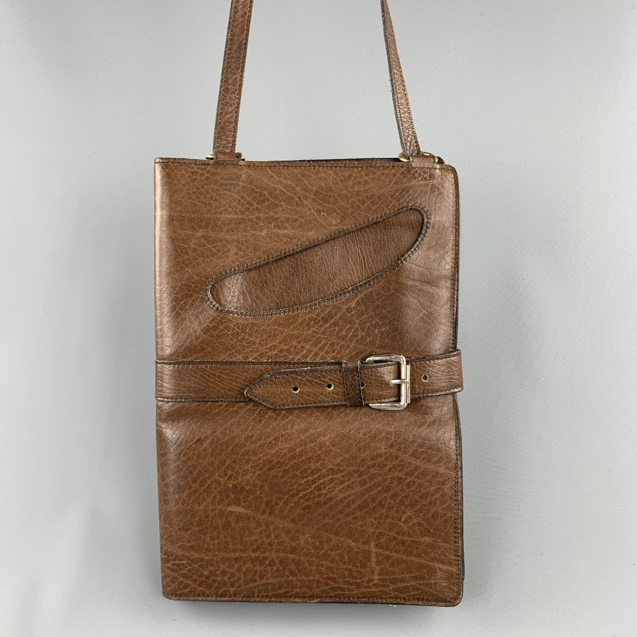 Vintage WILKES BASHFORD shoulder bag comes in a brown leather featuring a front cut out detail, inner pockets, and a strap buckle closure. Buckle strap ripped. As-Is. Made in Italy.

Very Good Pre-Owned Condition.

Measurements:

Length: 15 in.