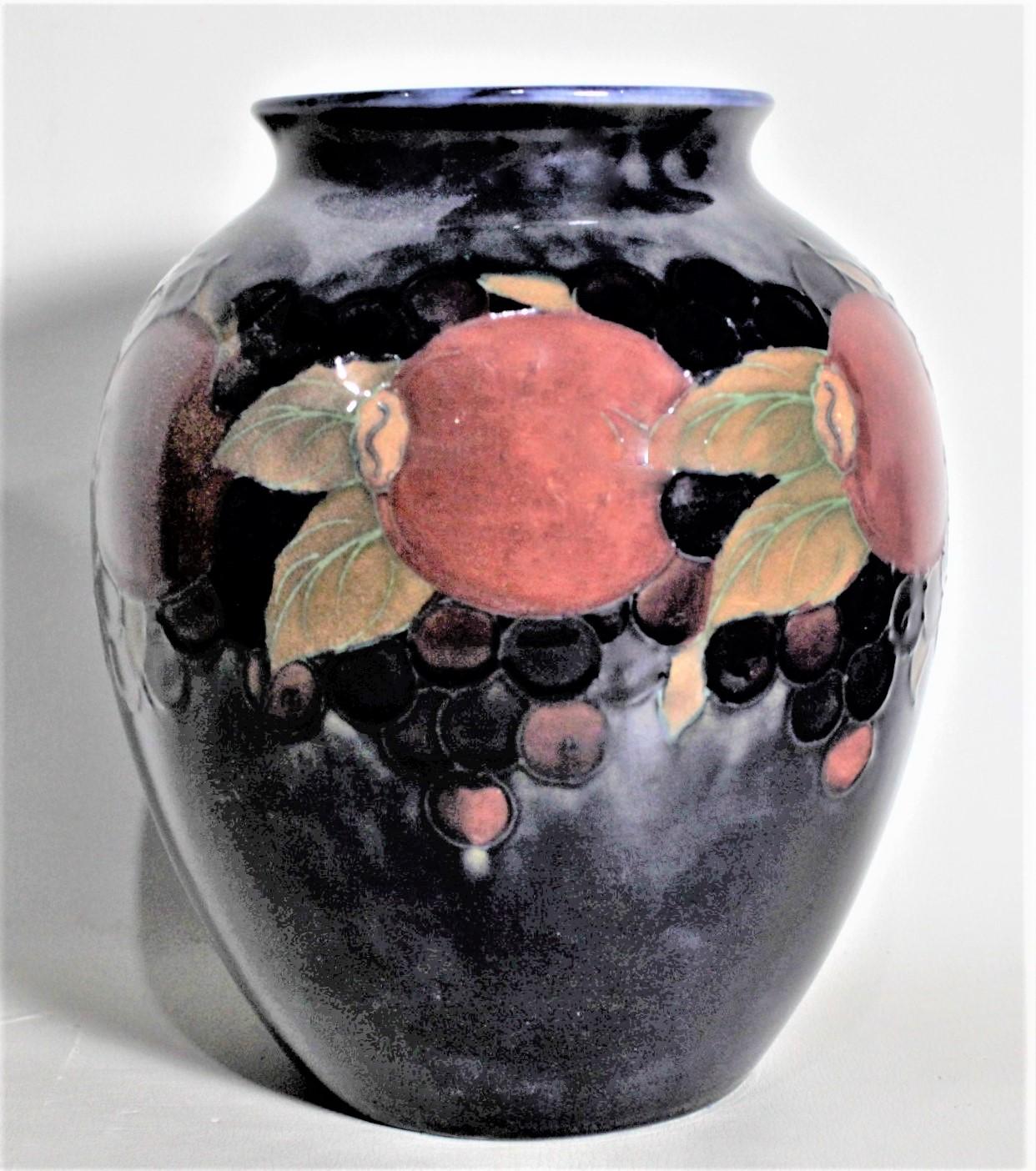 This art pottery vase was done by the Moorcroft Pottery company of England in circa 1939 using their signature deep cobalt blue ground and done in the 'Pomegranate' pattern. The vase is clearly signed on the base with impressed maker's marks, and