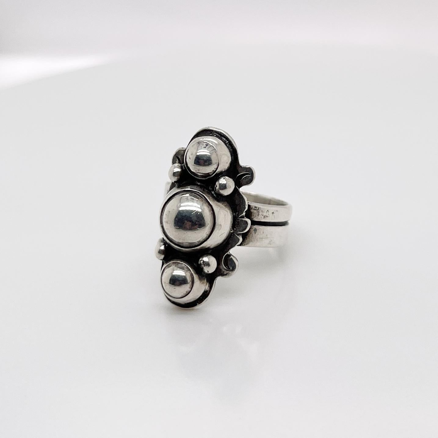 A very fine vintage William Spratling Mexican sterling silver ring.

With three sterling silver beads bezel set on patterned base and a double band ring.

Simply a terrific ring by one of Mexico's masters!

Date:
20th Century

Overall Condition:
It