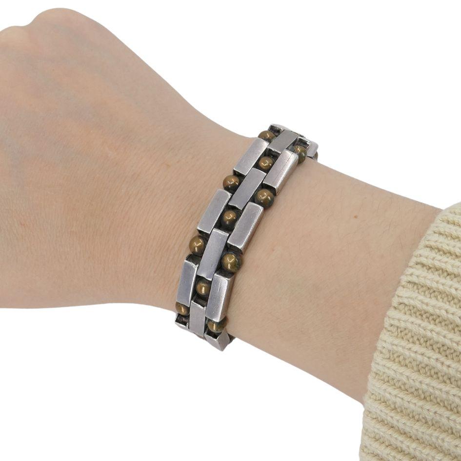 This vintage William Spratling Mexican silver bracelet is a collectible example from the early period of Spratling’s renowned designs. Crafted in sterling silver with bronze beads, the bracelet features a bold geometric link construction accented by