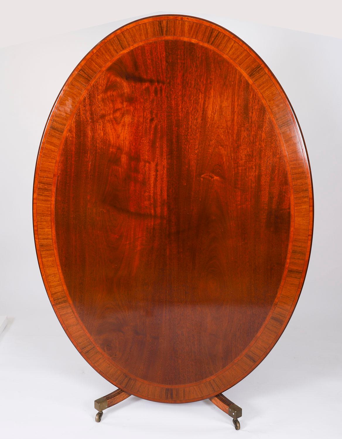 Il s'agit d'une fabuleuse table de salle à manger Regency Revival vintage, fabriquée par le maître ébéniste William Tillman dans les années 1990 et portant son label. 

Cette magnifique table de salle à manger ovale est fabriquée en acajou flammé