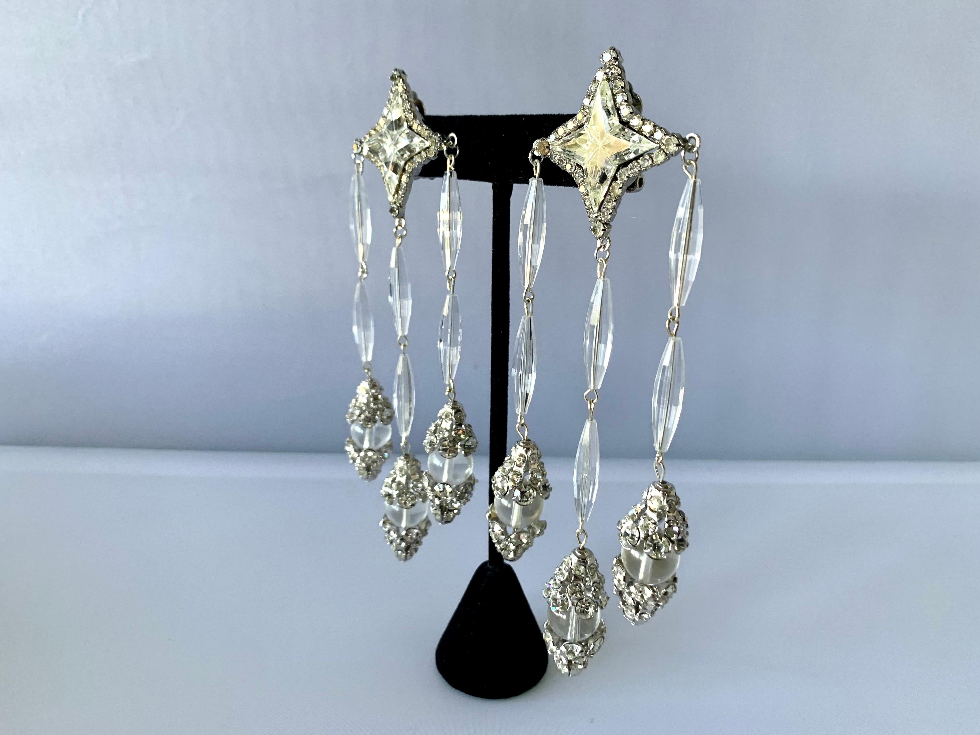 Exceptional imposing vintage William de Lillo star chandelier clip-on statement earrings. Comprised out of clear acrylic faceted beads, Swarovski glass rhinestones, and German navette glass rhinestones - hand constructed by Robert F. Clark for