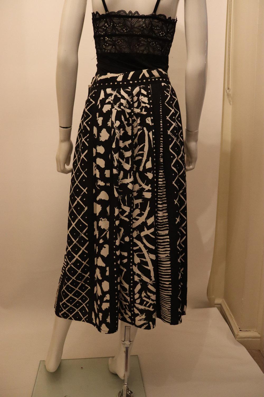 A chic vintage skirt and top / jacket by British brand Windsmoor, in a stylish black and white print.
The skirt opens with 4 buttons , 2 each side and is unlined. The jacket is collarless, has 2 breast pockets , single button cuffs , an adjustable