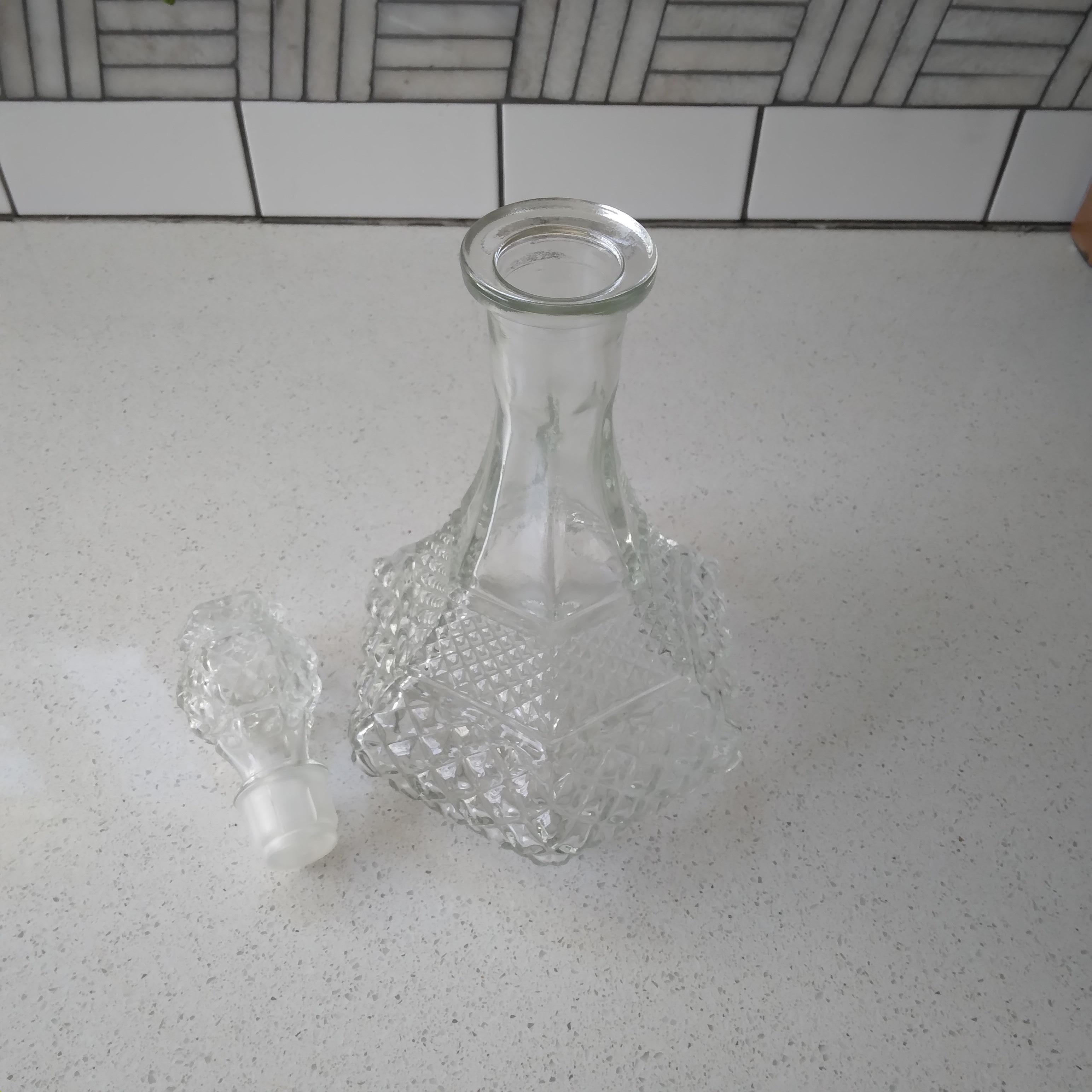 Beautifully faceted, this crystal (clear glass) wine decanter is quite mesmerizing. We love the Wexler diamond pattern, featuring two sizes of diamonds at the generous, square base. The top culminates in a removable flower shaped stopper.

The thick
