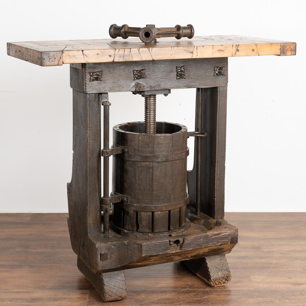 This unique wine tasting table or standing bar/table was created with an antique wine press from Hungary as the intriguing base.
The top is made from old boxcar/railroad car flooring which lends a strong balance to the industrial feel of the lower