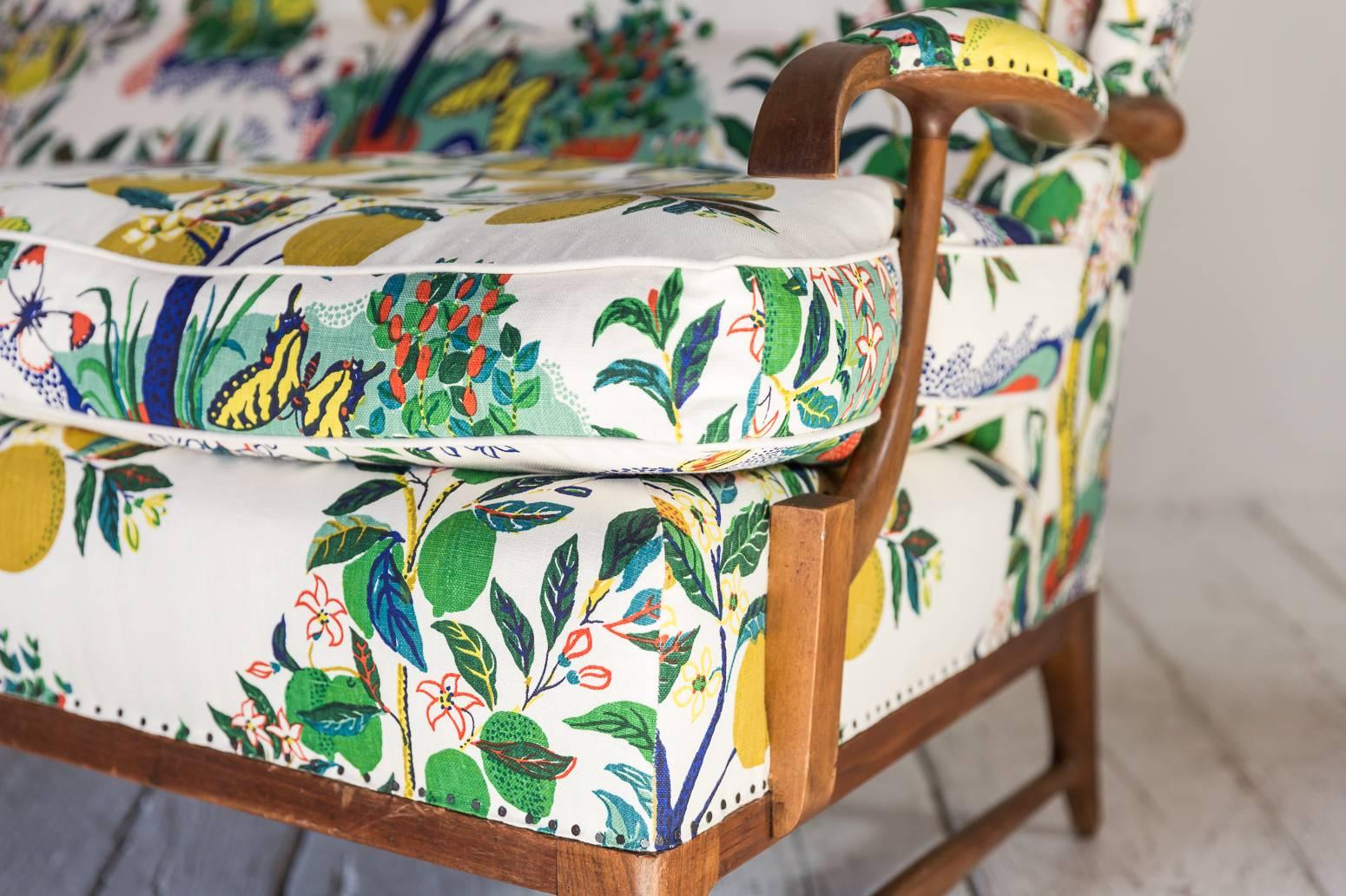 Vintage wingback settee newly upholstered in colorful Josef Frank fabric. Beautiful oak exposed arms and base. Nails used for nailheads.