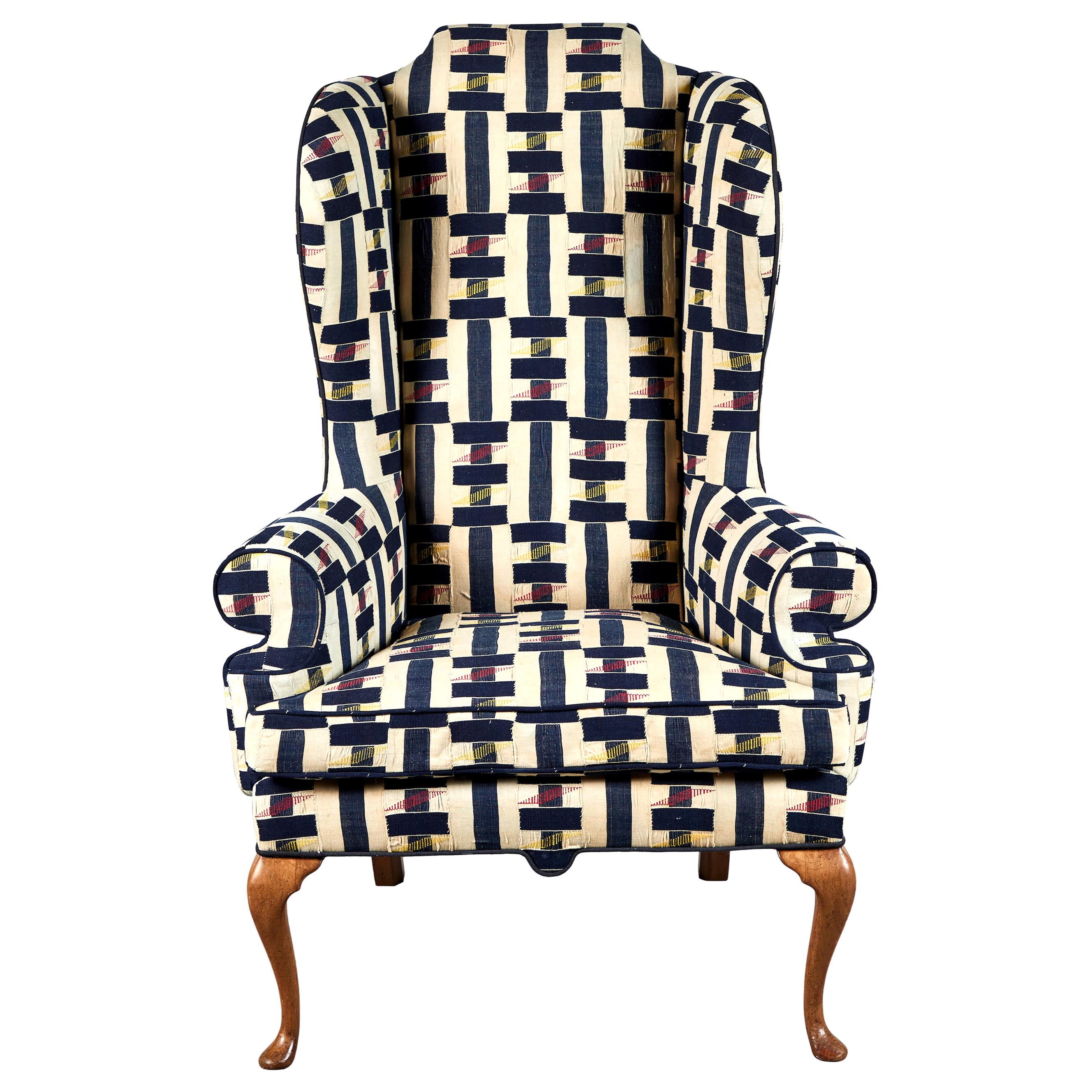 Vintage wingback chair in multicolored ewe fabric from Ghana, the African fabric is beautifully textured and handmade with accents of navy, natural and red. The chair is finished in a solid piping, the chairs have original finish on the cabriole
