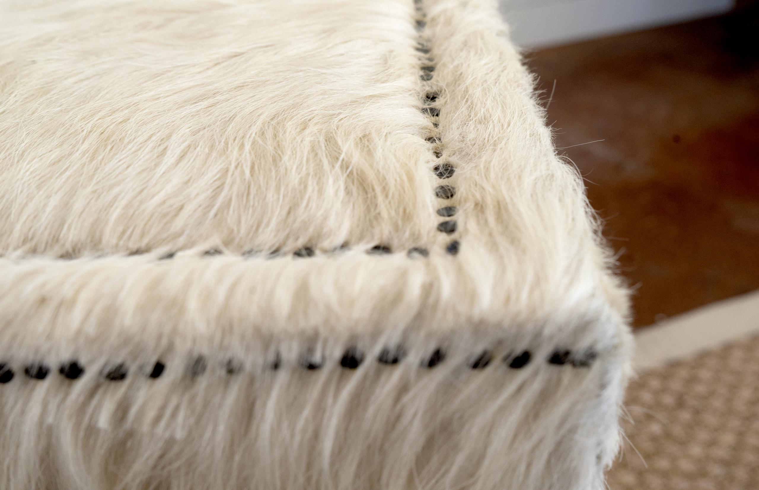 Table basse vintage avec une peau de vache longueur hiver couvrant toute la table. Les têtes de clous françaises accentuent le style magnifique de cette pièce.