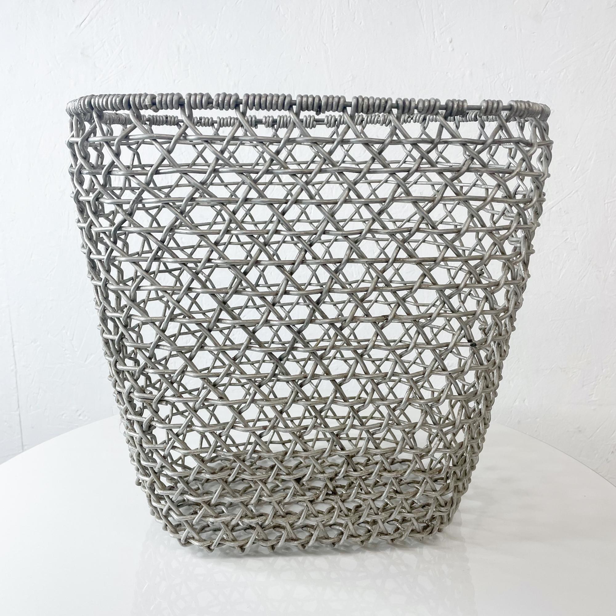 Basket
Vintage woven Aluminum Wire basket, Open grid. Open container.
No label present.
Original vintage preowned unrestored condition. Presents firm and sturdy. No damage. 
12.75 H x 13.25 W x 10.25 D inches
Refer to images.

 