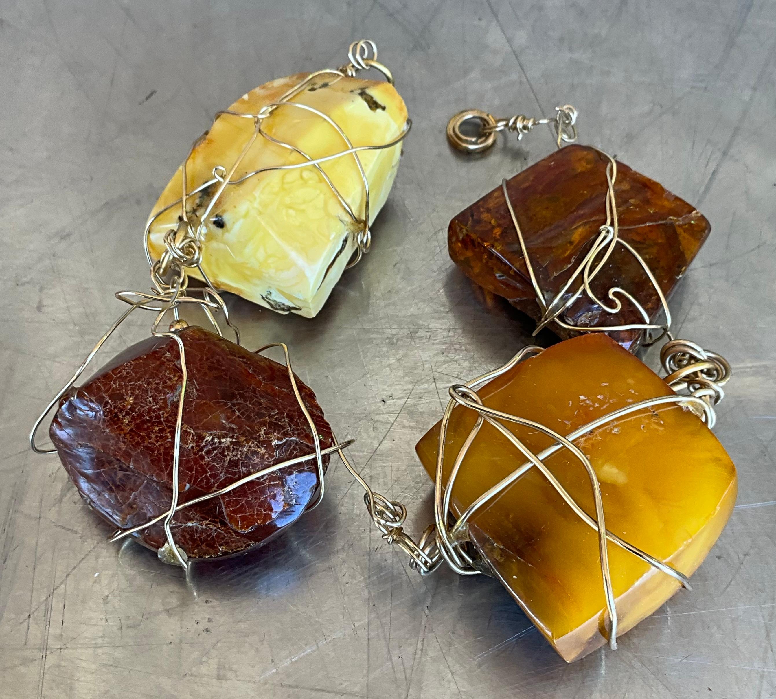 Esta pulsera vintage de alambre de ámbar es una pieza exquisita inspirada en el estilo distintivo de la renombrada diseñadora de joyas Kazuko Oshima. Hecha a mano con precisión artística, la pulsera presenta piedras de ámbar de un rico tono miel,
