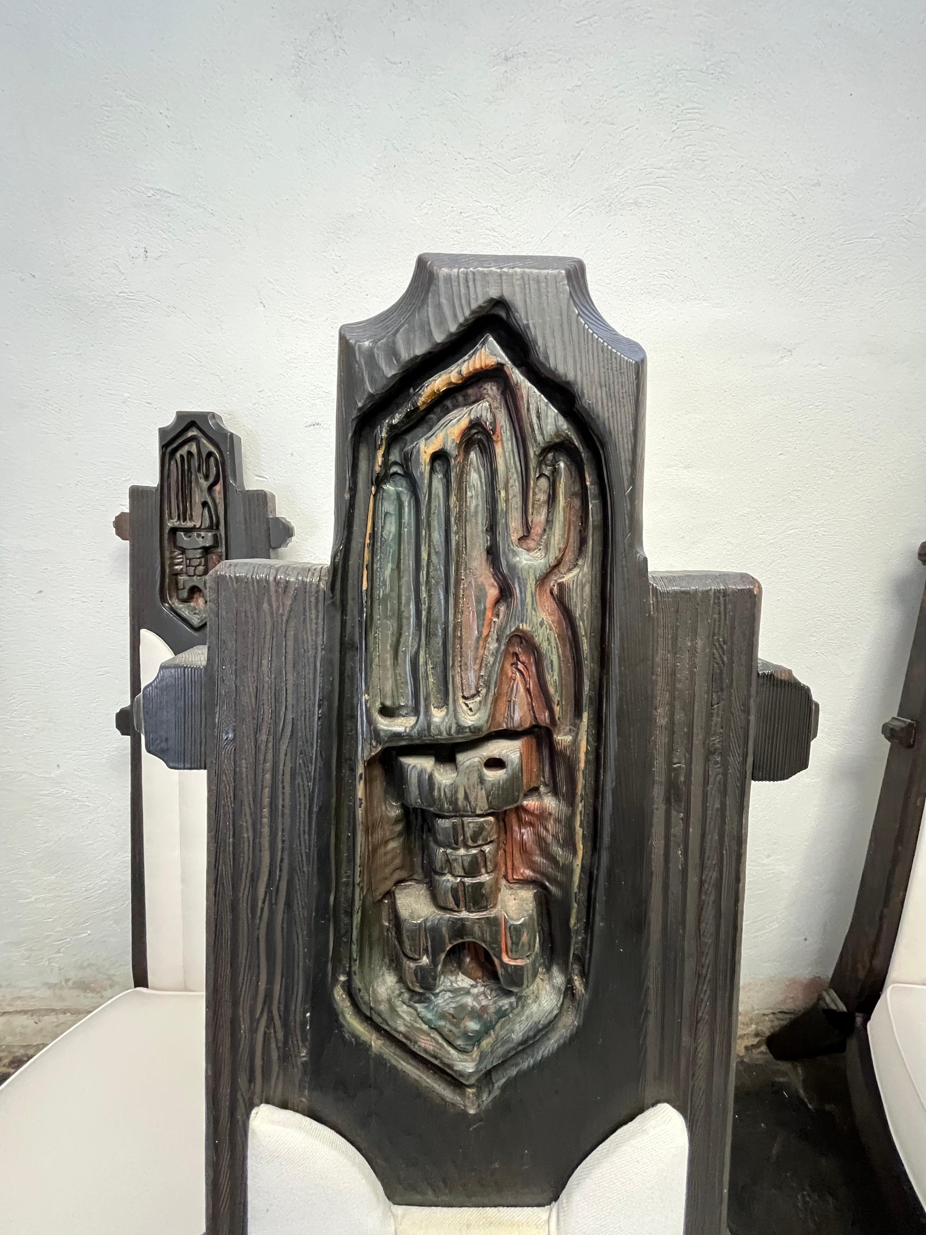 Sedie da pranzo brutaliste in legno intagliato in stile Elvis Jungling. Alla maniera di William Westenhaver/Witco. L'articolo è caratterizzato da uno scudo con schienale alto e una base intagliata a forma di leone con un'imbottitura in cotone