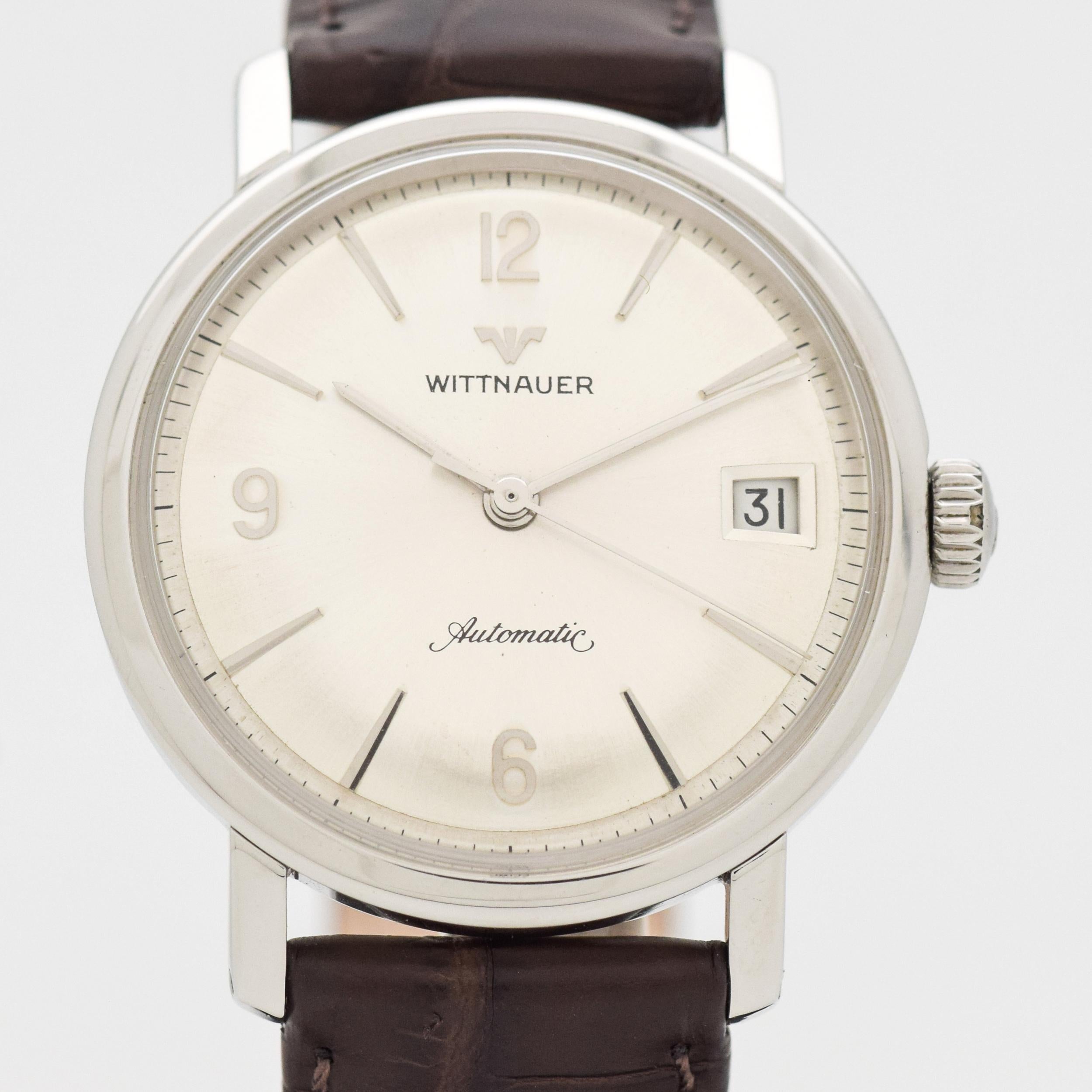 1960's Vintage Wittnauer Automatic Reference 9002. Stainless Steel Case. 34mm wide. Silver dial with applied, Arabic numerals & bar markers. Powered by a 17-jewel, automatic caliber movement. Triple Signed. Swiss-made.