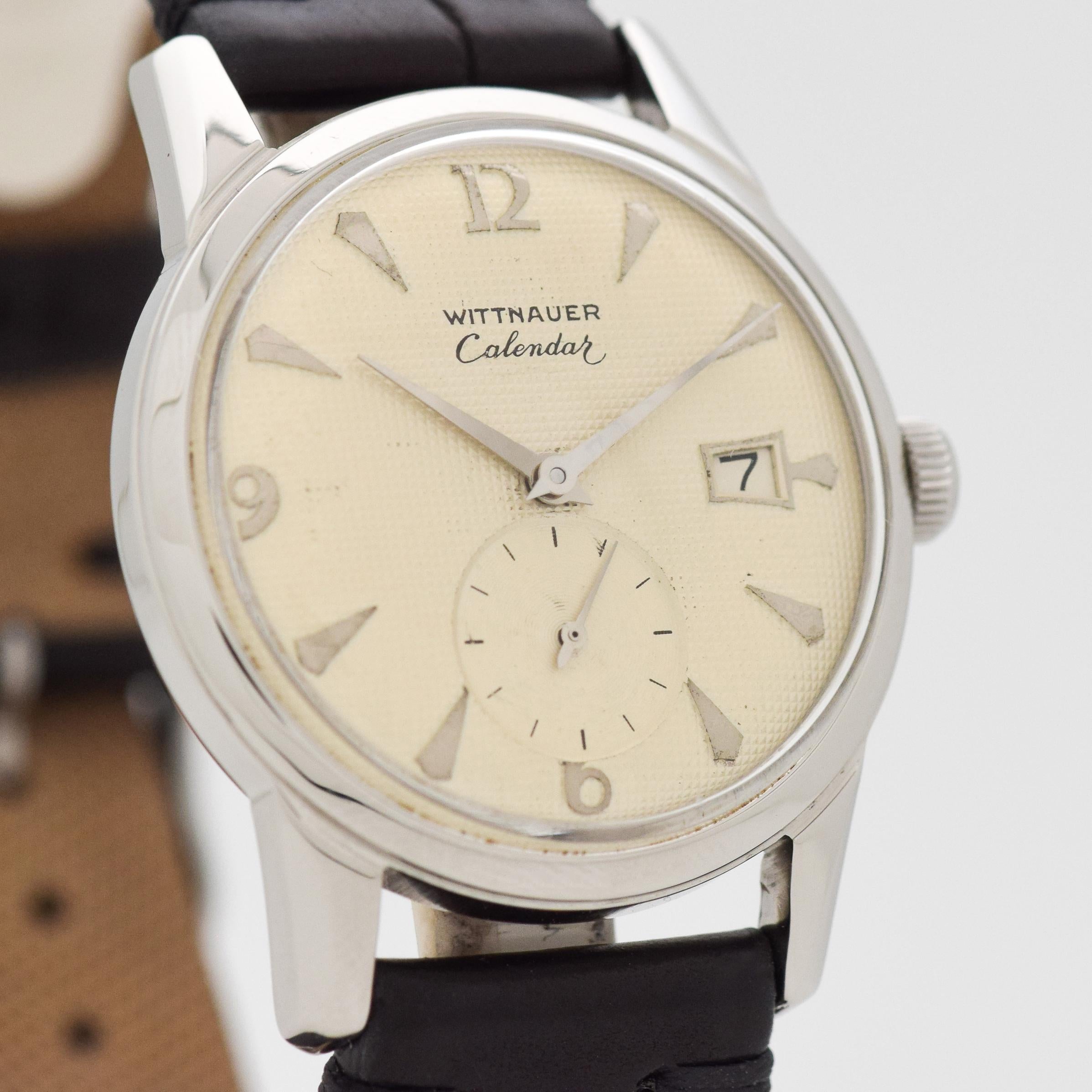 1960's Vintage Wittnauer Calendar Stainless Steel watch with Original Silver Waffle Textured Dial with Applied Steel Arabic 6, 9, and 12 with Elongated Tapered Steel Markers. 34mm x 41mm lug to lug (1.34 in. x 1.61 in.) - 17 jewel, manual caliber