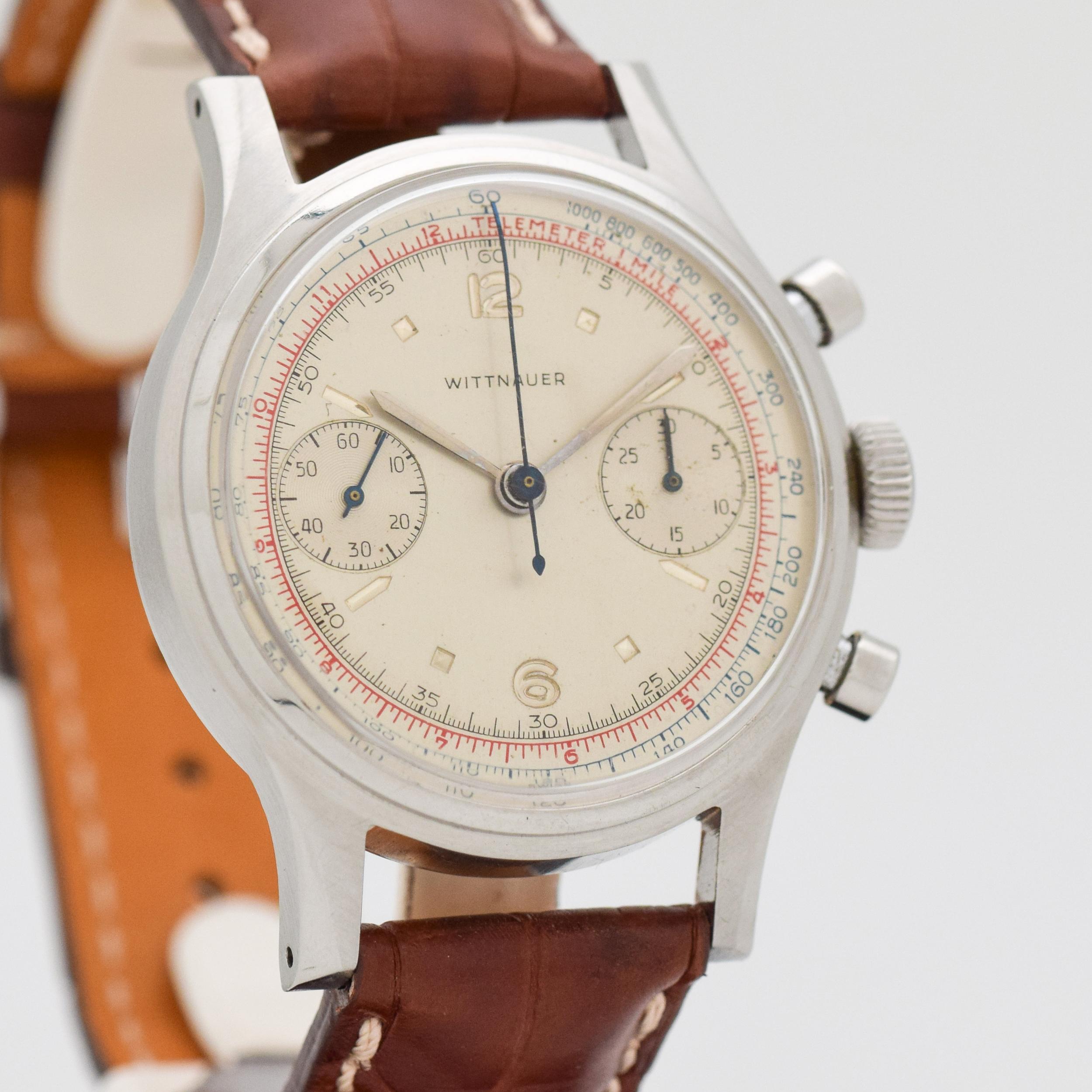 a 1960's Vintage WIttnauer Chronograph 2-Register Watch. Stainless Steel watch case that measures in at 36mm wide. Original, silver dial. Powered by a manual-wind, Venus 188 movement. Featured on a Matte Brown-colored, Longines Alligator watch
