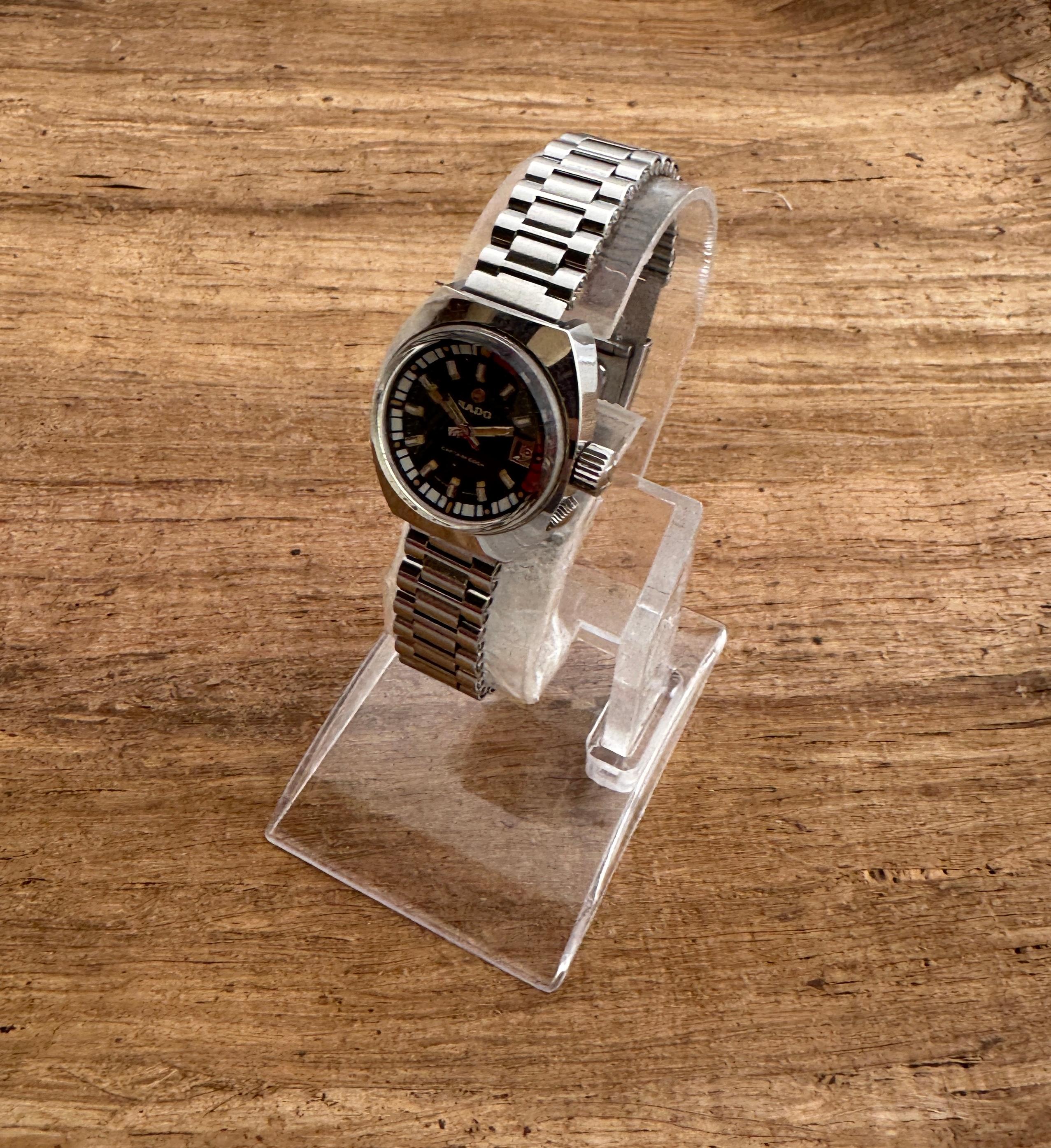 
Brand : Rado

Model: CAPTAIN COOK

Reference Number: 727/1

Country Of Manufacture: Switzerland

Movement: Automatic

Case Material: Steel

Measurements 25mm diameter (excluding crown )

Band Type : Stainless Steel With Marked Buckle

Band
