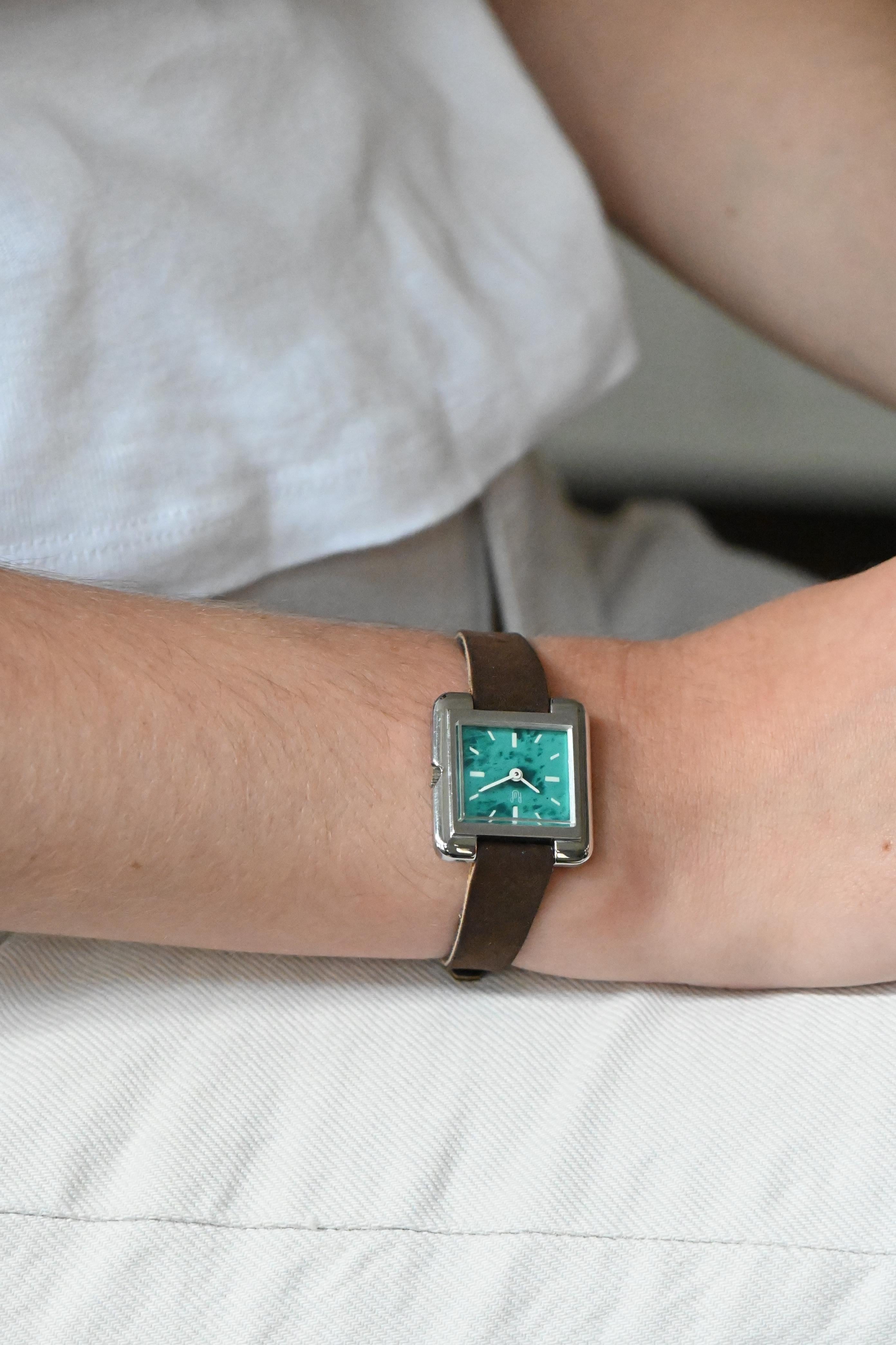 Cette petite montre vintage pour femme de Rof Prestige est un véritable bijou d'élégance estivale. Son fond vert de mer, idéal pour l'été, apporte une touche de fraîcheur et de sophistication. Le bracelet en cuir assure un confort optimal et un
