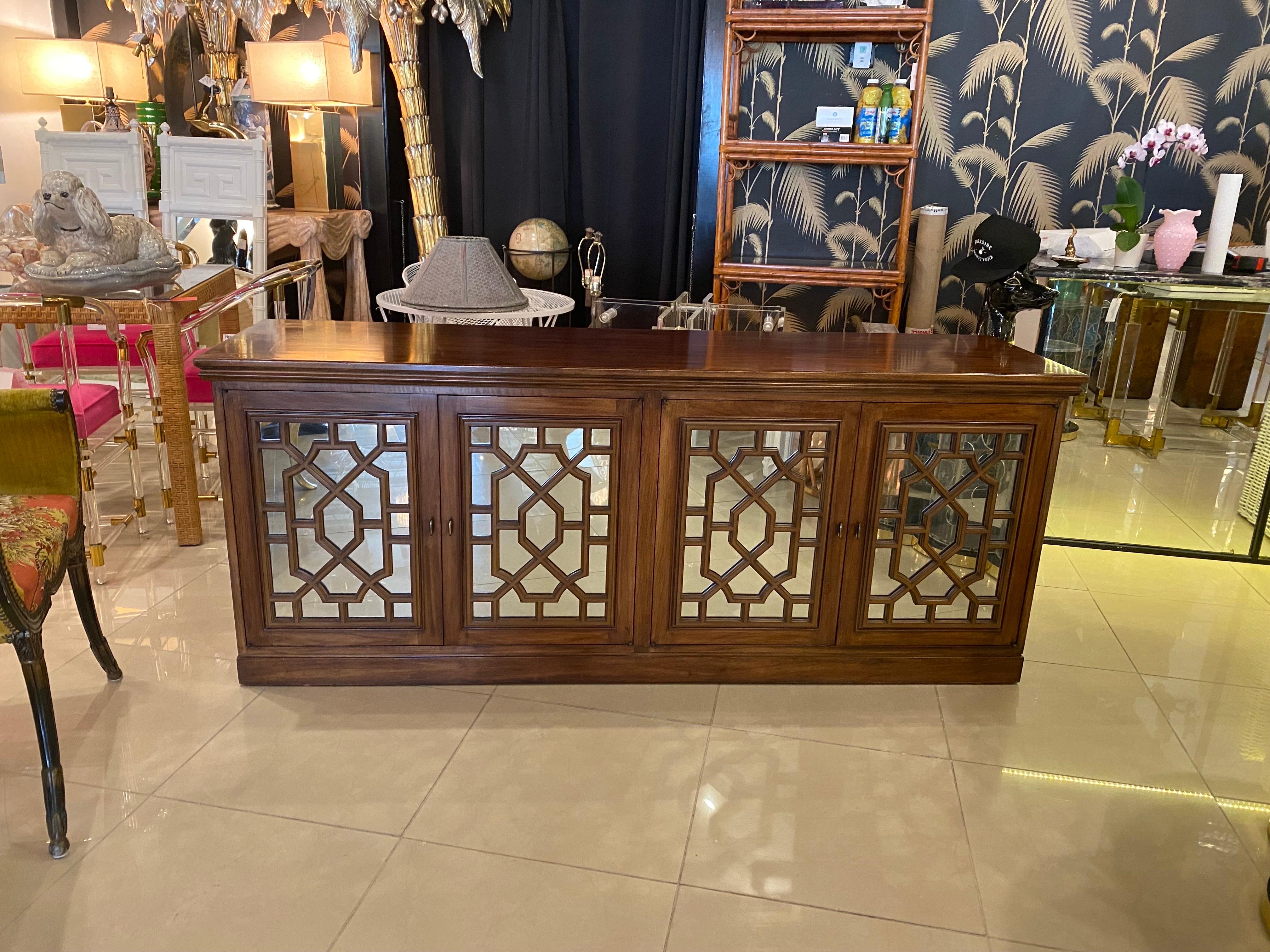Beautiful vintage wood credenza, buffet, sideboard with mirrored doors and fretwork. Each pair of doors open to reveal one adjustable shelf on each side. There are a few scuffs and scratches on the original wood finish, pictured. This would be