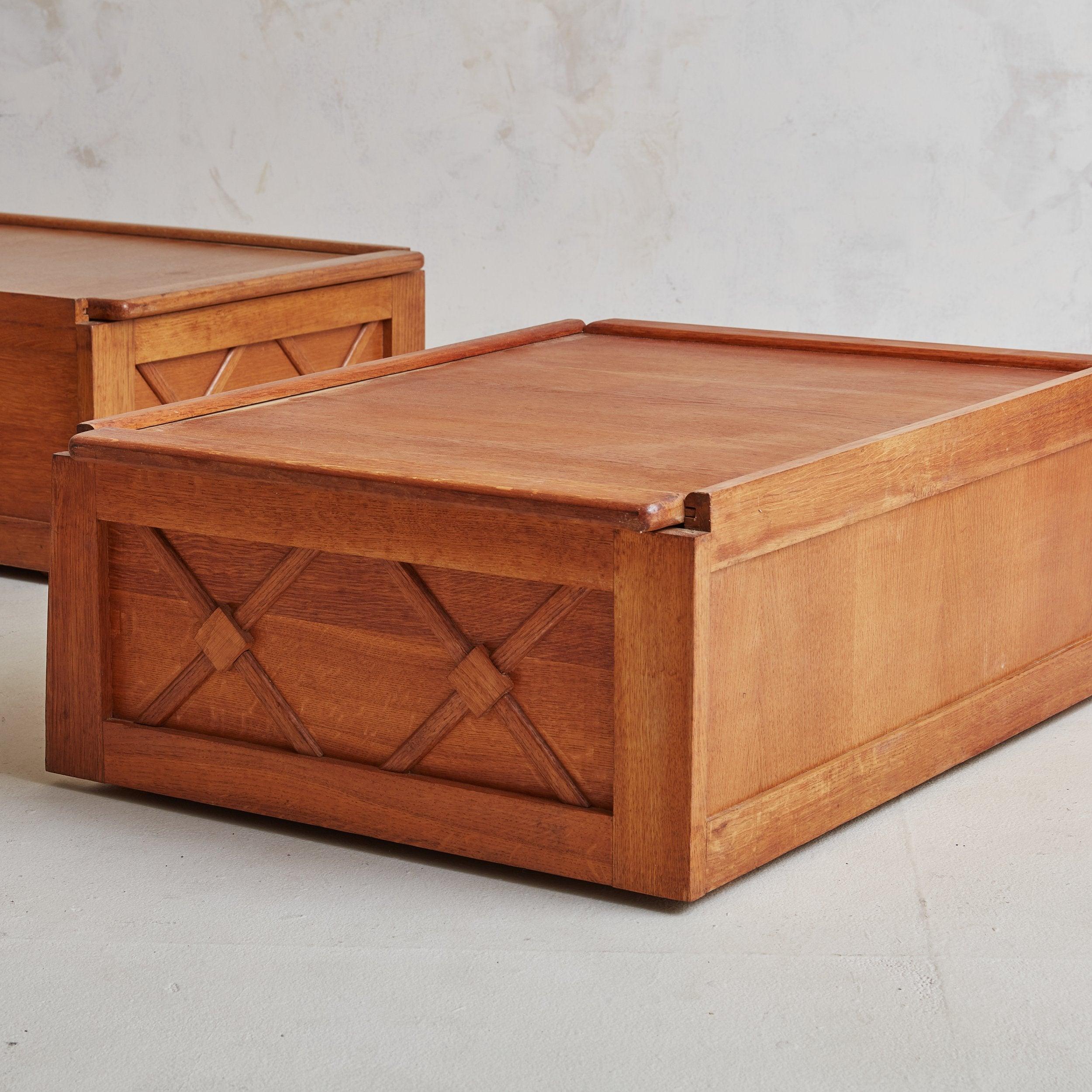 A vintage rectangular wood coffee table in a gorgeous warm cherry hue featuring a sliding top and concealed storage space. The sides are inset with crisscross geometric wood panels, resembling a trellis pattern. Four wheels support the base,