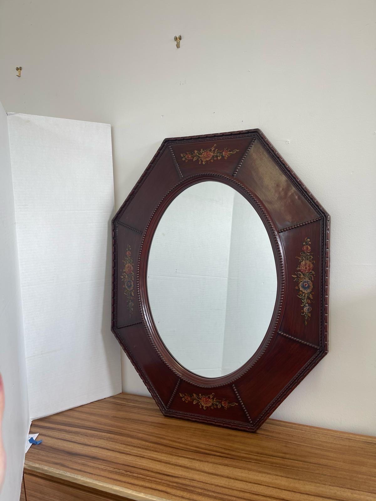 The Mirror itself Is Oval Shaped with an Octagonal Frame. Hand Painted Floral Design on Four Sides. Makers Mark on the Back as Pictured. Vintage Condition Consistent with Age as Pictured.

Dimensions. 34 W ; 1 D ; 26 1/2 H