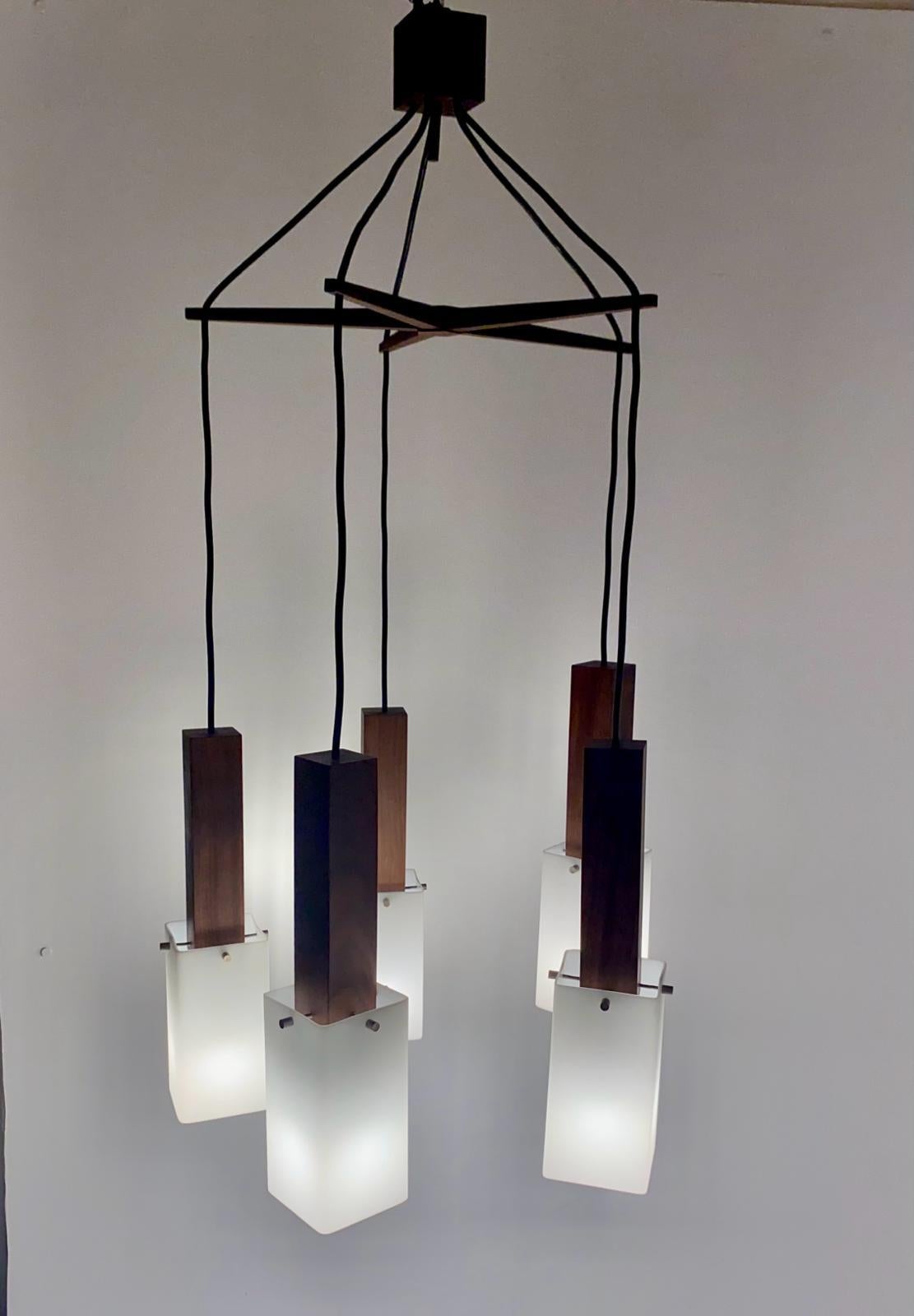 Rare vintage wood five spot Hanging lamp manufatured by Guzzini, Italy in the 1960 's.

Solid wood frame and plexiglass lampshades. Nicely refined dark colored teak wood structure and intect lampshades. Elegant wood finishing and lampshades details.