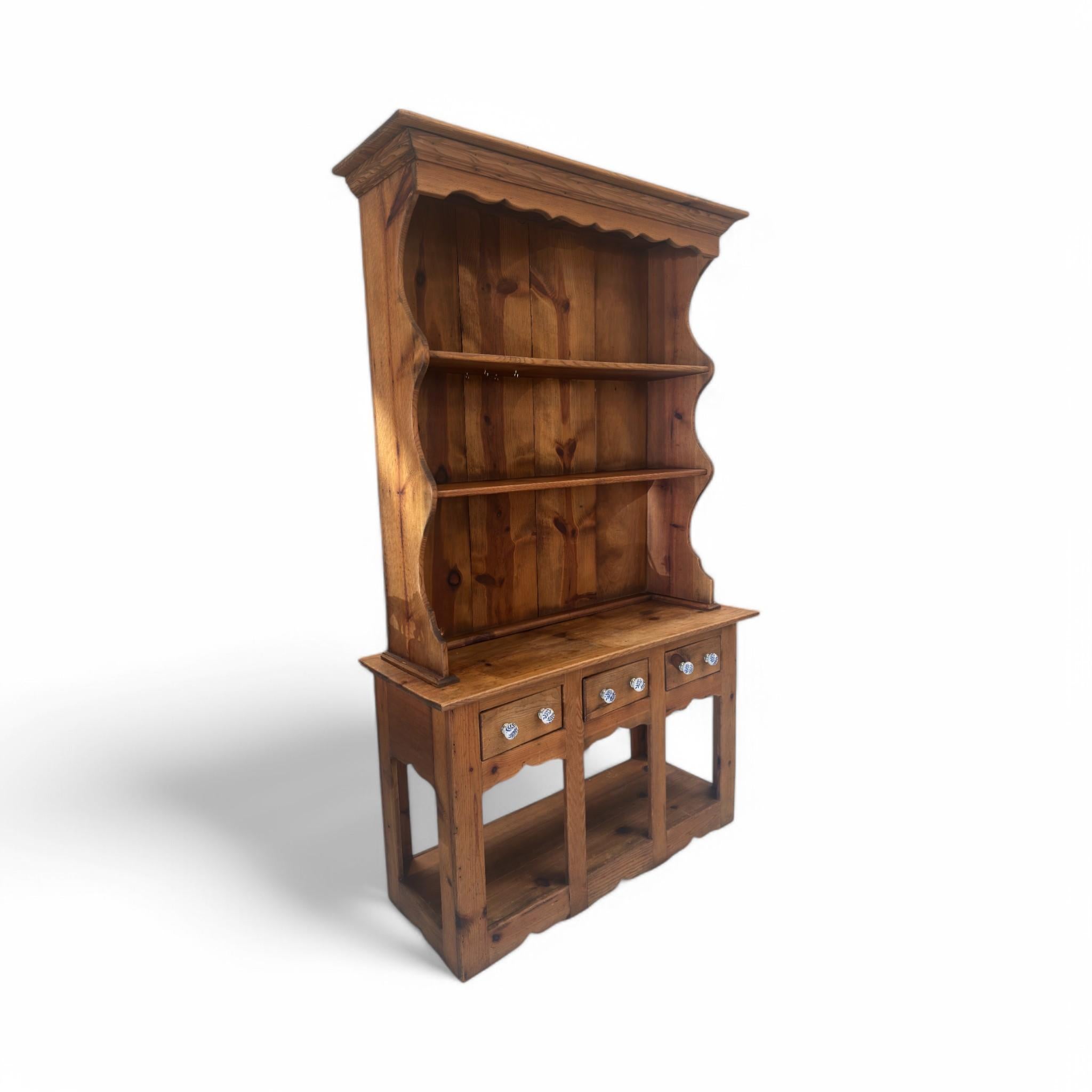 Débordant de charme rustique, cette huche de cuisine vintage offre à la fois style et fonctionnalité. Sa silhouette joliment incurvée, ses étagères ouvertes spacieuses et ses quatre tiroirs dotés de boutons décoratifs en font un meuble idéal pour