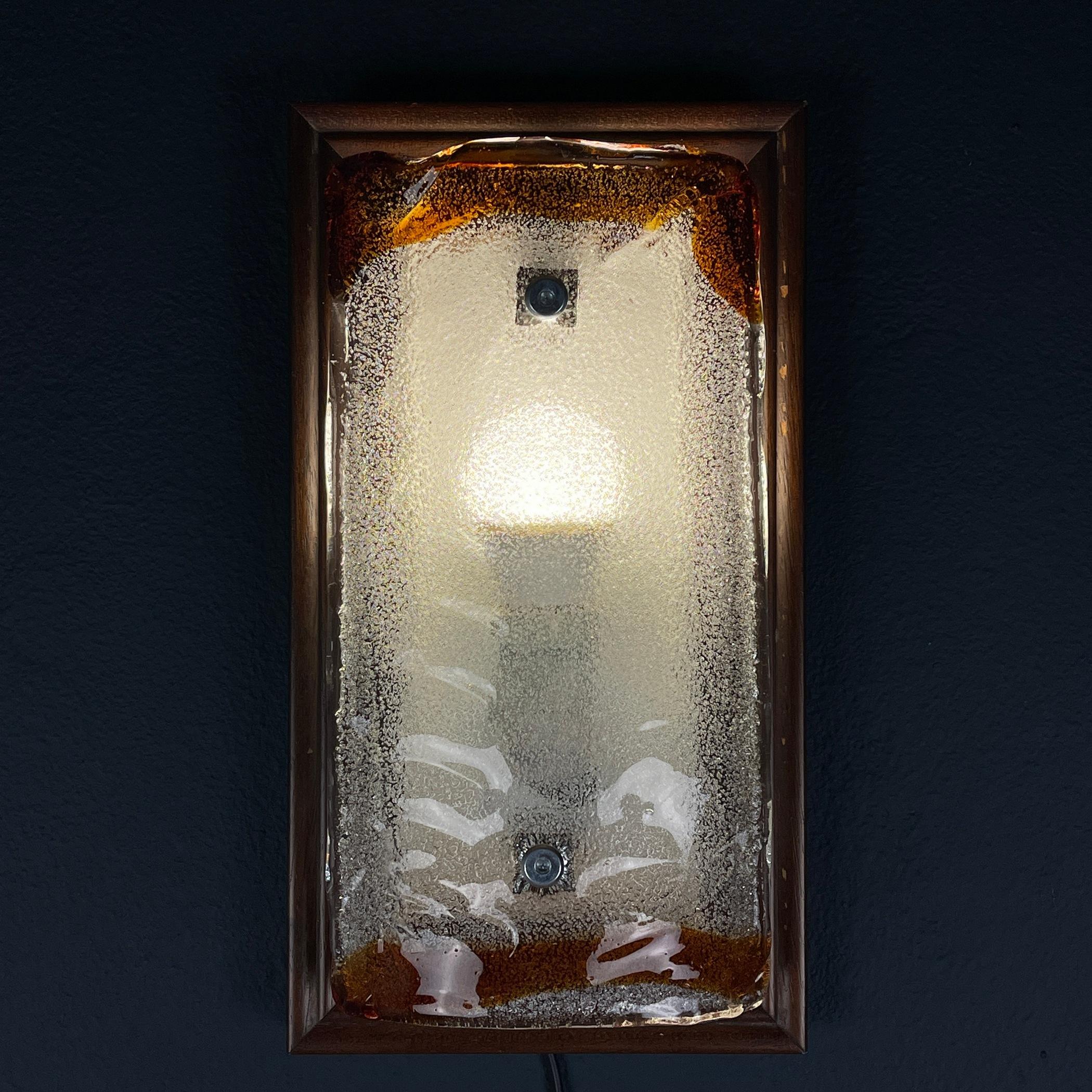 Elevate your space with the timeless charm of this vintage Murano wall lamp, a stunning embodiment of 1970s Italian Mid-Century Modern design. This sconce boasts a captivating wood frame, exuding both elegance and style. Embrace the allure of Murano
