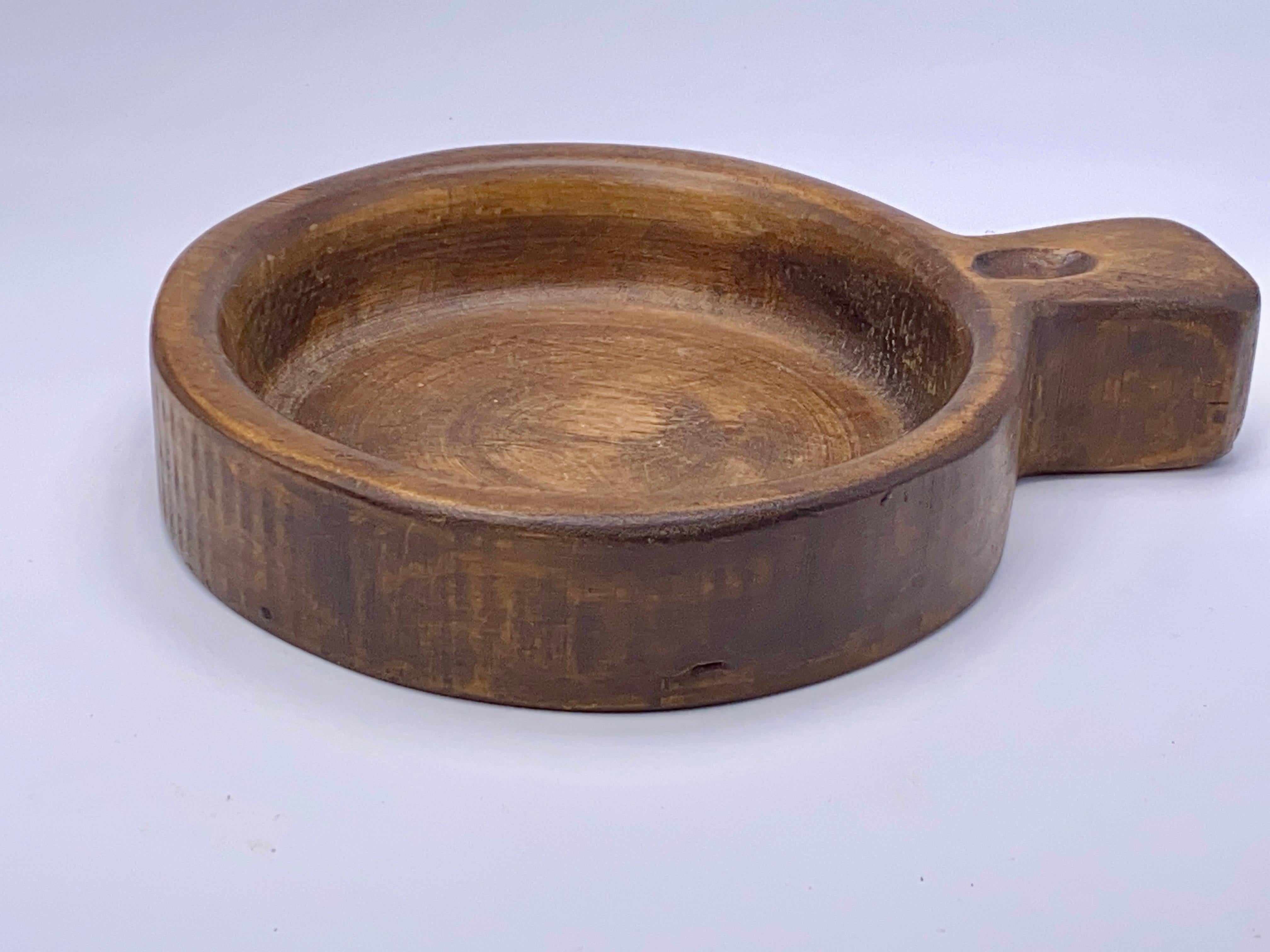 This tray is with an handle, you can use it to any need for the kitchen or dinning table, as well as a vide poche too. It has been done in france circa 1960, and it is in wood, in a brown color.