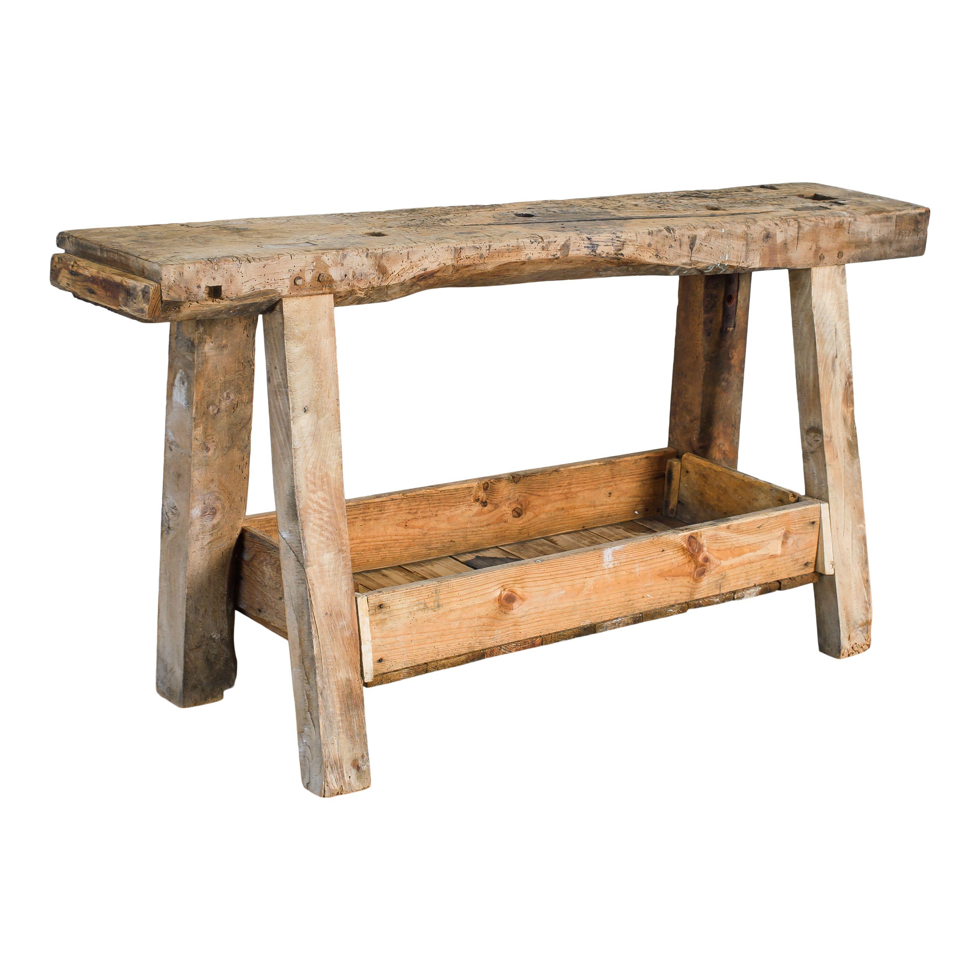 Un desgastado banco de trabajo vintage de madera procedente de Francia: la mesa perfecta. La parte superior es una gran pieza de hermosa madera desgastada y las patas tienen la clásica forma triangular. Hay un estante con laterales cerca de la parte