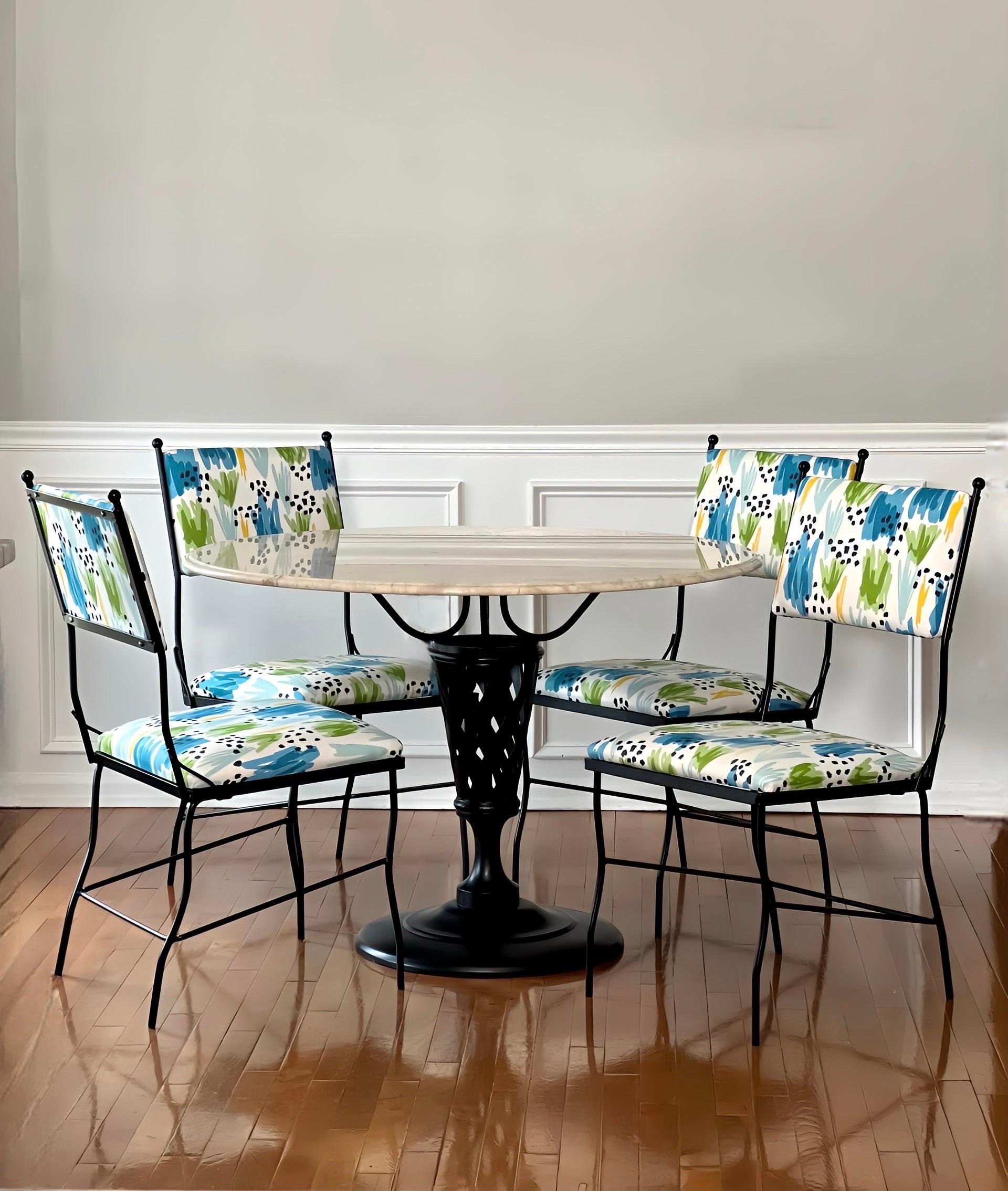 Woodard vintage midcentury black wrought iron and marble dining set with upholstered chairs.  A shapely cone form pedestal with a lattice pattern on a circular base supports a new sculpted edge 42-inch round cream marble top.  The set has been