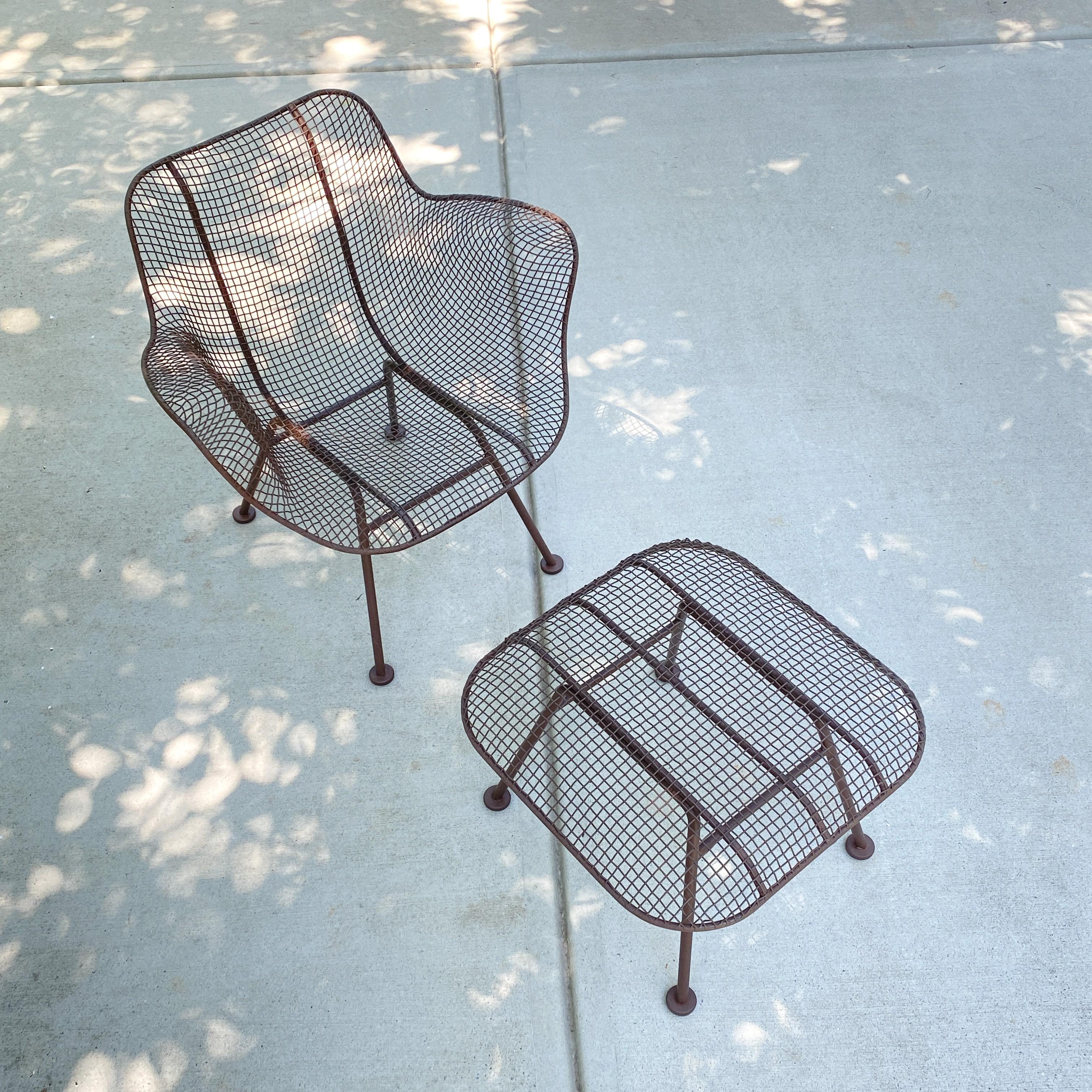A vintage painted wrought iron lounge chair and ottoman manufactured by Woodard, the two pieces are from Woodard's Sculptura line. The Sculptura line was first introduced in 1956 and was one of the first lines not produced from molds. In 1994 a