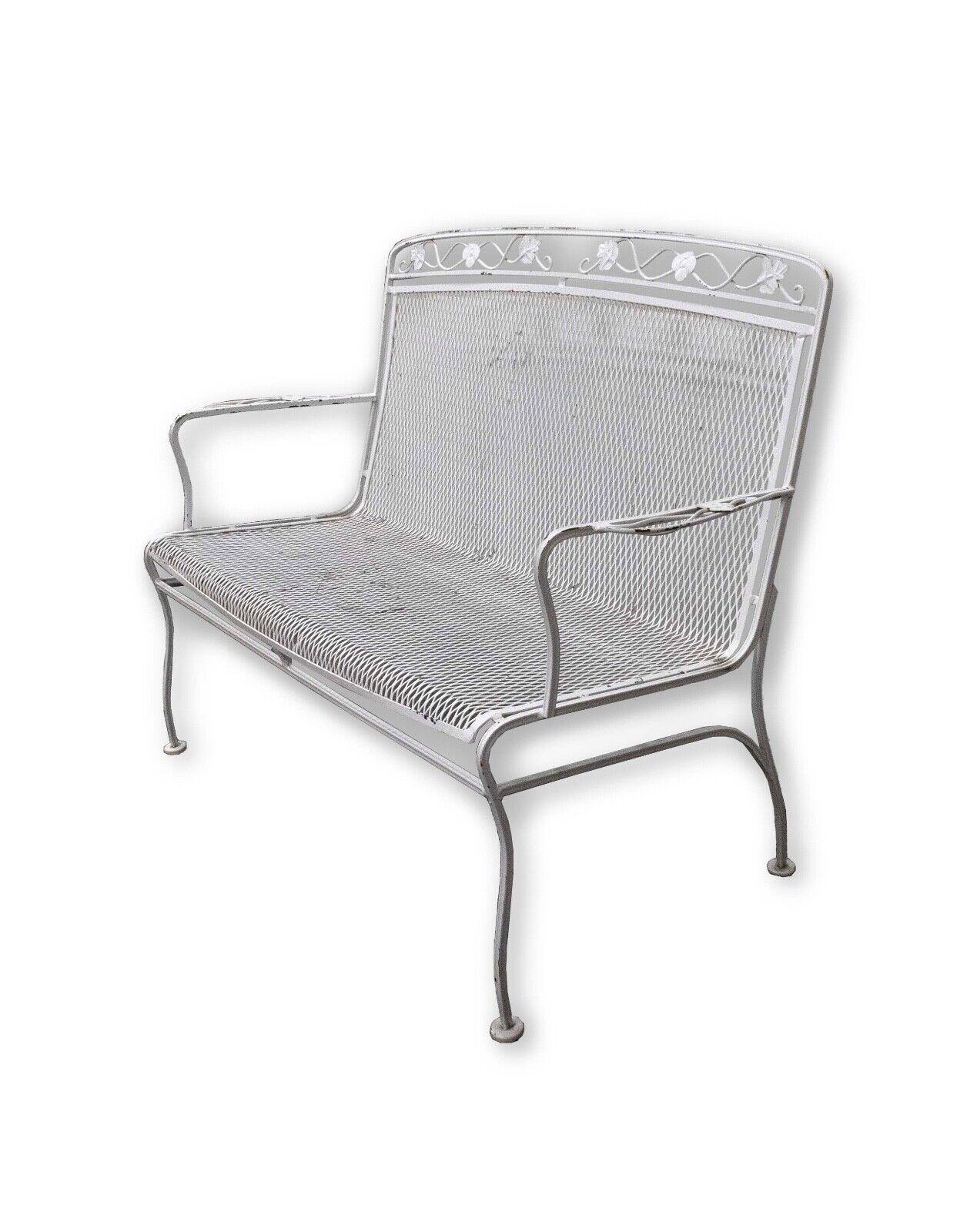 The Vintage Woodard White Wrought Iron Garden Bench Settee is a stunning representation of mid-century modern design for your outdoor space. Crafted by Woodard, a renowned name in wrought iron furniture, this garden bench settee boasts a timeless
