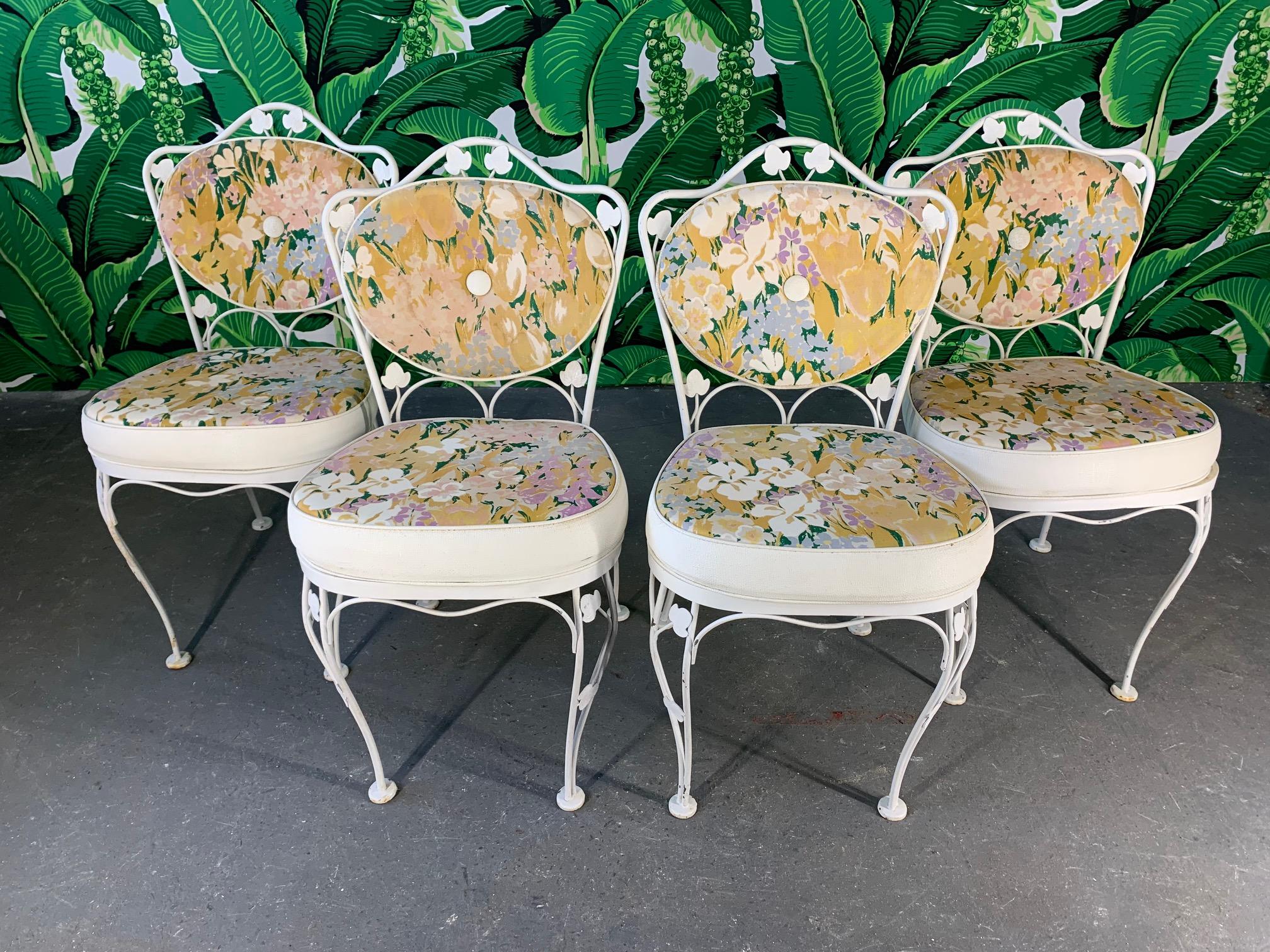 Vintage wrought iron patio set by Lee Woodard and Sons (father of Russell Woodard) features original floral upholstery and decorative ivy detailing. Includes 4 wrought iron chairs and an all-aluminum table. Good vintage condition with imperfections