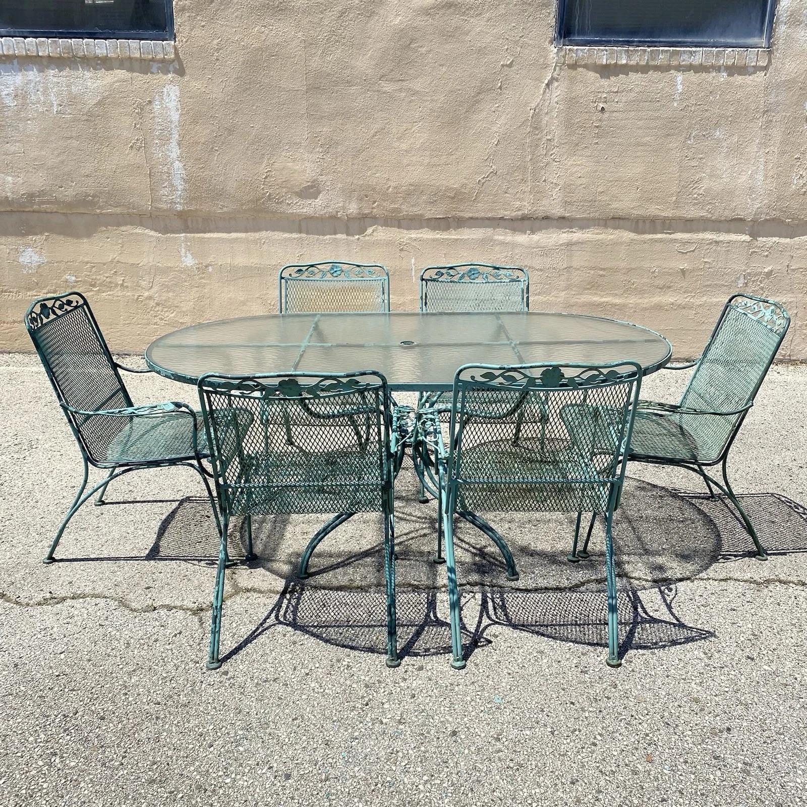 Vintage Woodard Wrought Iron Patio Dining Set with Long Oval Glass Top Dining Table & 6 Dining Armchairs with Flower and Vine Details - 7 Pcs. Circa Late 20th Century. Measurements: Table (No glass): 29