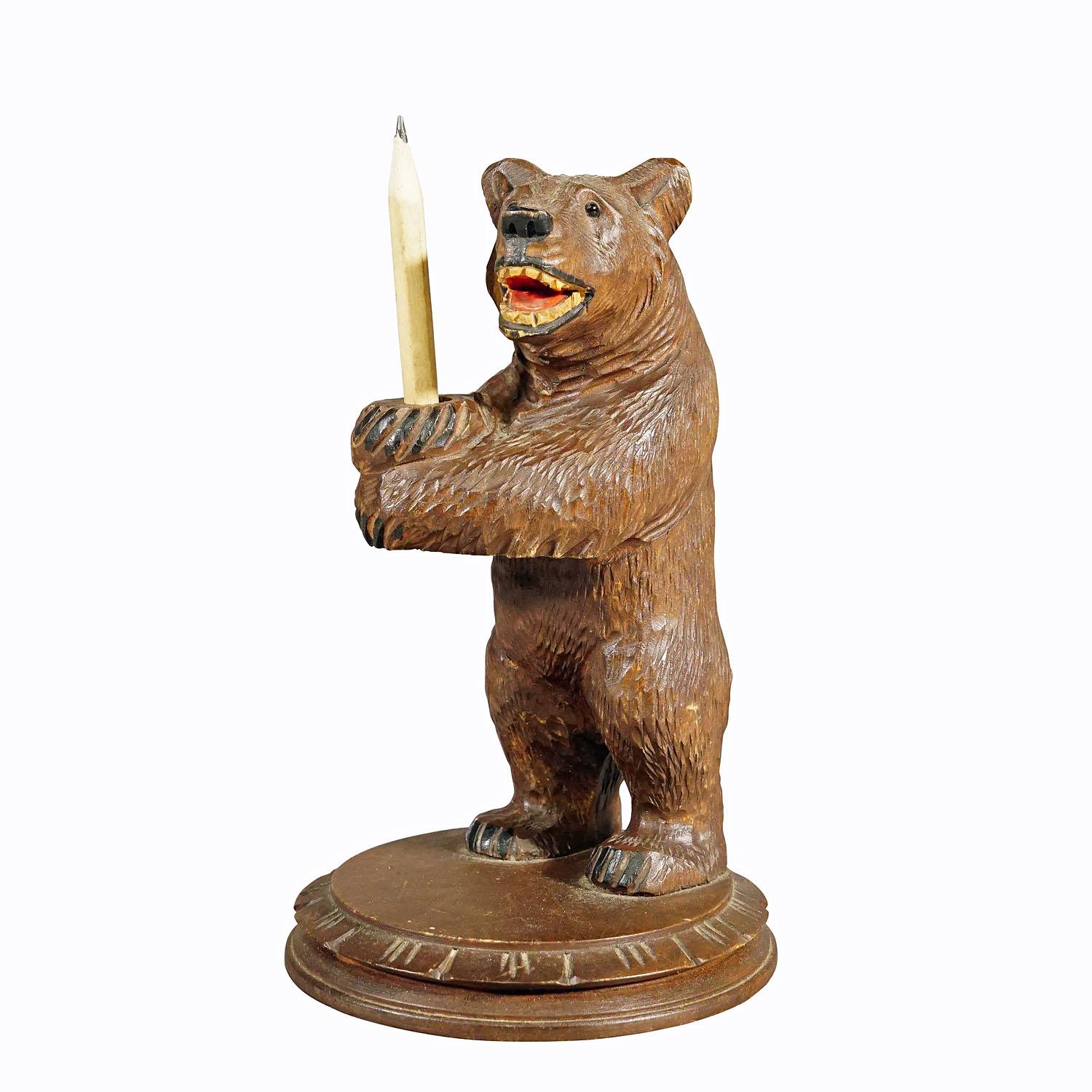 Vintage wooden bear pencil holder hand carved in Brienz circa 1930s.

A vintage statue of a Black Forest bear holding a pencil. Made of lindenwood, finely hand carved with naturalistic details in Brienz, Switzerland ca. 1930s. An authentic example