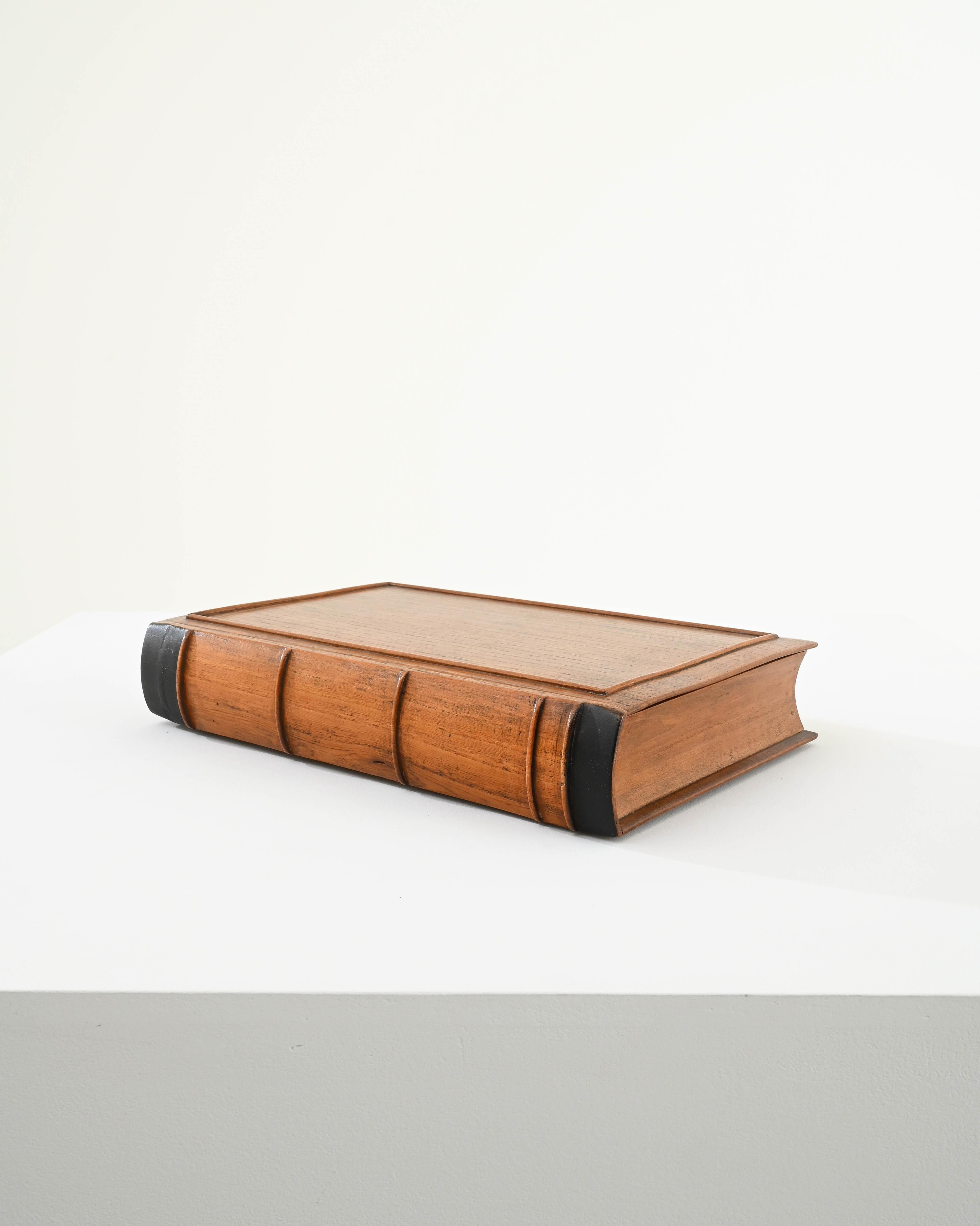Whimsical and unique, this wooden box shaped like a leather-bound book is sure to delight any bibliophile. A realistic and detailed appearance, hand carved in oak creates a discrete and charming appearance. The front cover of the book lifts apart to