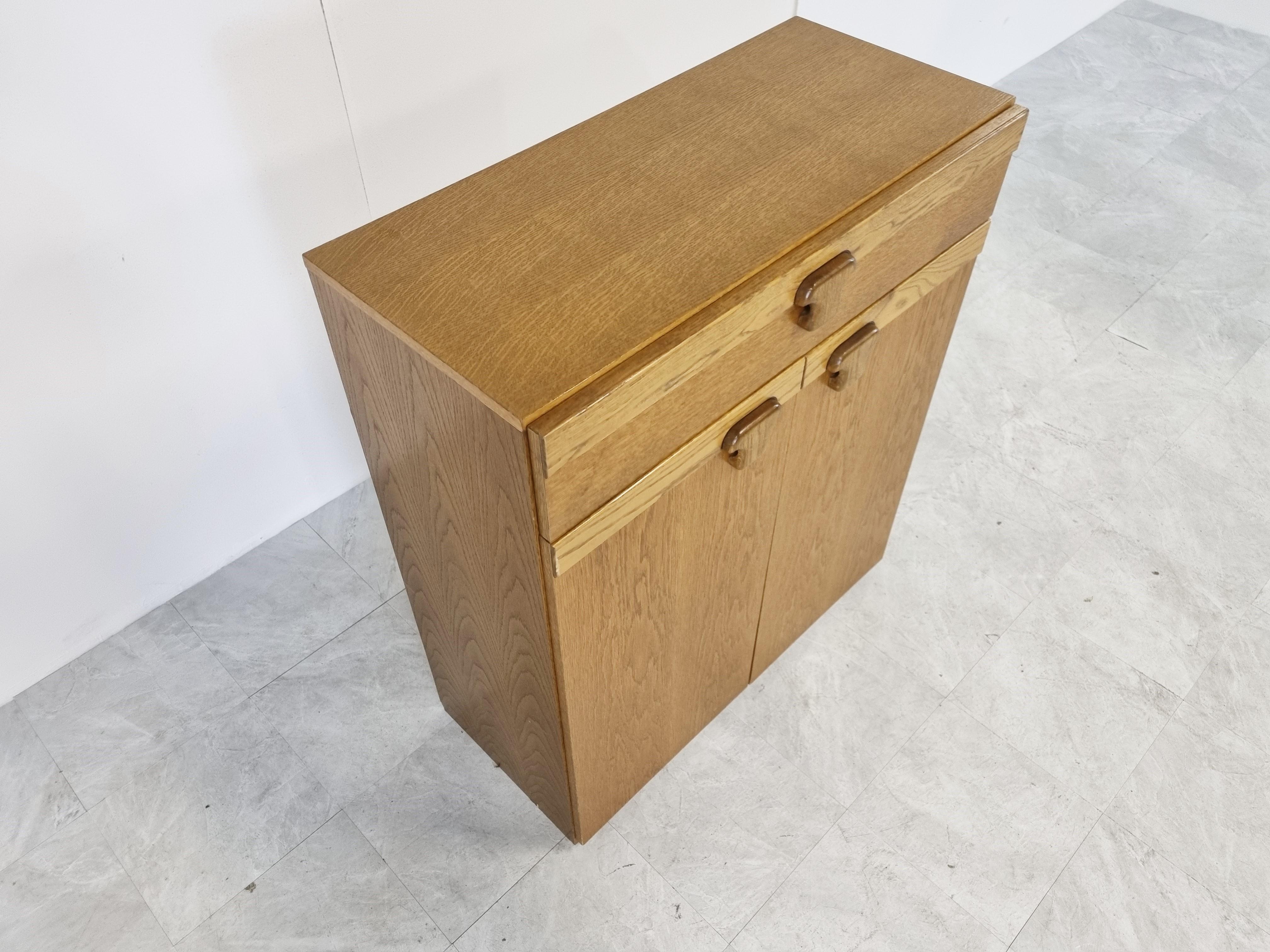 Vintage oak cabinet with two doors and one drawer with cool handles.

Good condition

1960s - Belgium

Dimensions:
Height: 99cm/38.97