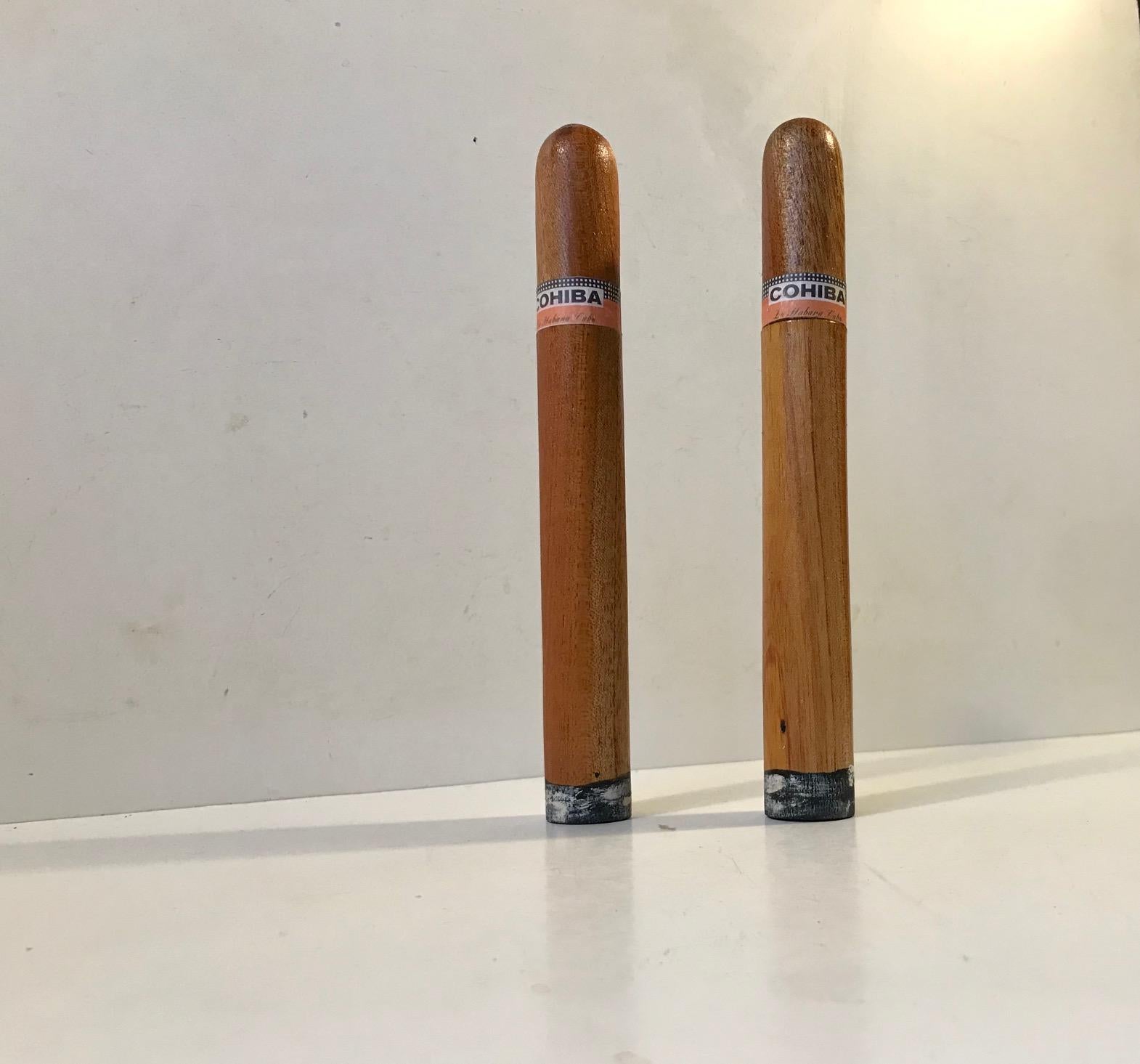 A set of vintage cigar tubes from Cohiba. They are made from teak and dates to the 1960s. They still contain Cohiba cigars one of which is missing 1 inch of the outer leaves. These cigars will be gifted along with the tubes.