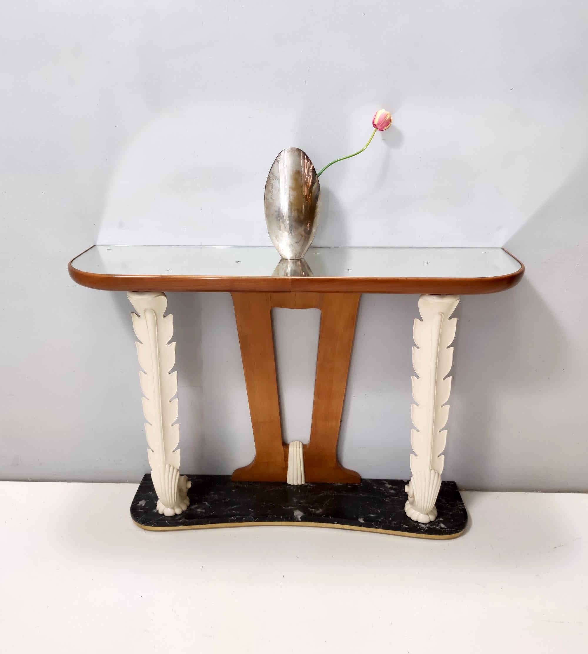 Fabricado en Italia, años 40.
Esta consola tiene un tablero de espejo con estrellas incrustadas, un marco de madera de cerezo y haya lacada, una base de mármol Portoro y detalles de latón. 
La parte superior es probablemente de Fontana Arte.
Se