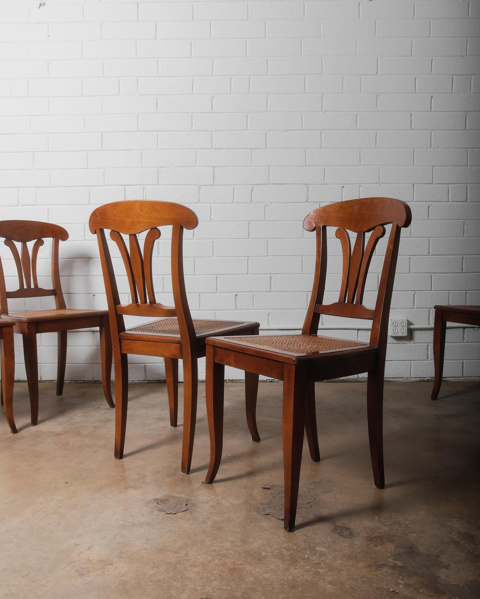 Améliorez votre espace repas avec ce magnifique ensemble de six chaises de salle à manger vintage en bois, inspirées des styles Regency Revival et provincial français du début au milieu du XXe siècle (années 1920-1950). Ces chaises présentent un