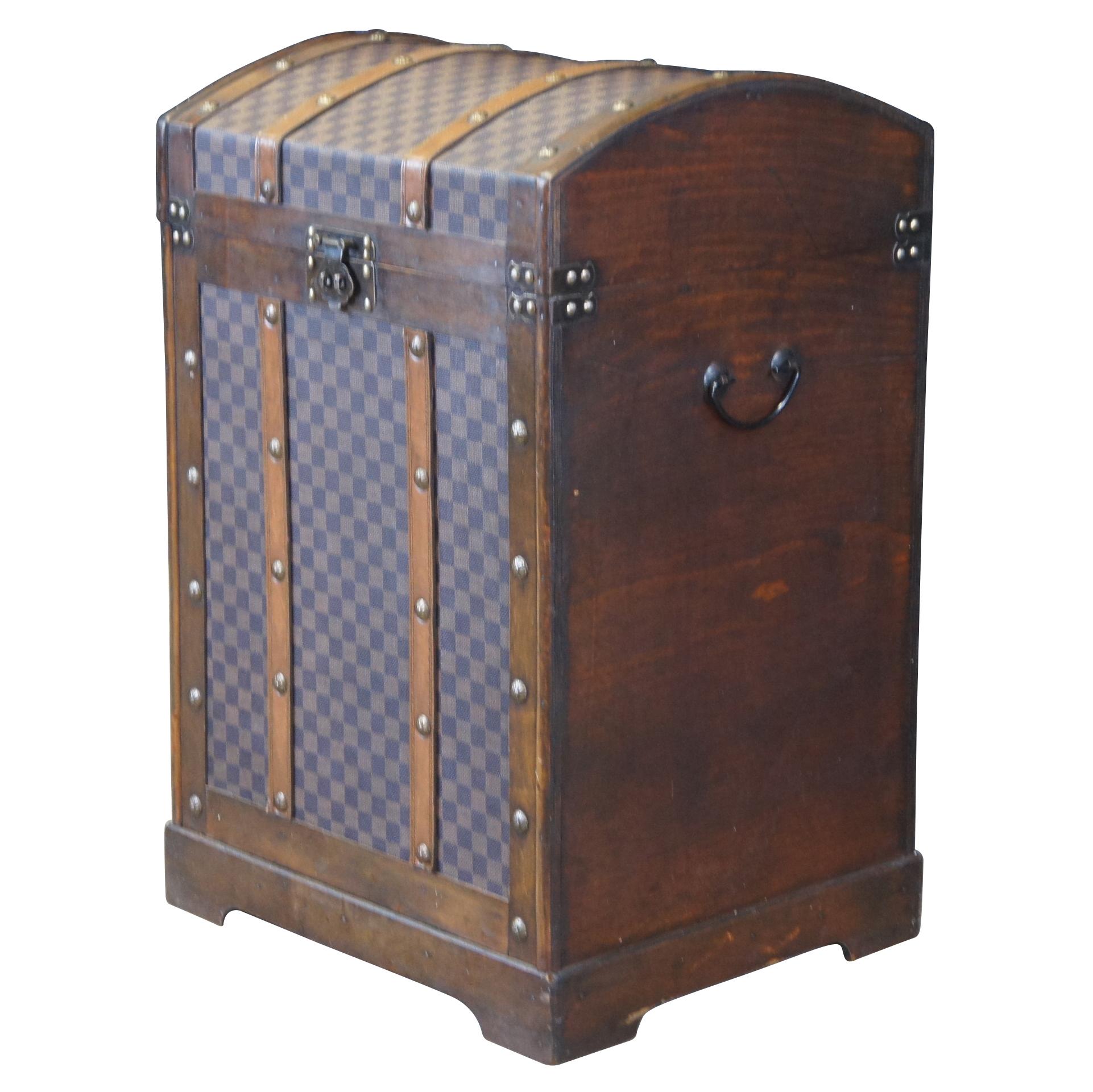 A lovely dome top storage trunk. Features a tall form with a framed wood exterior, faux leather monogrammed canvas and metal hardware. Great for display or storage.  Size: 28