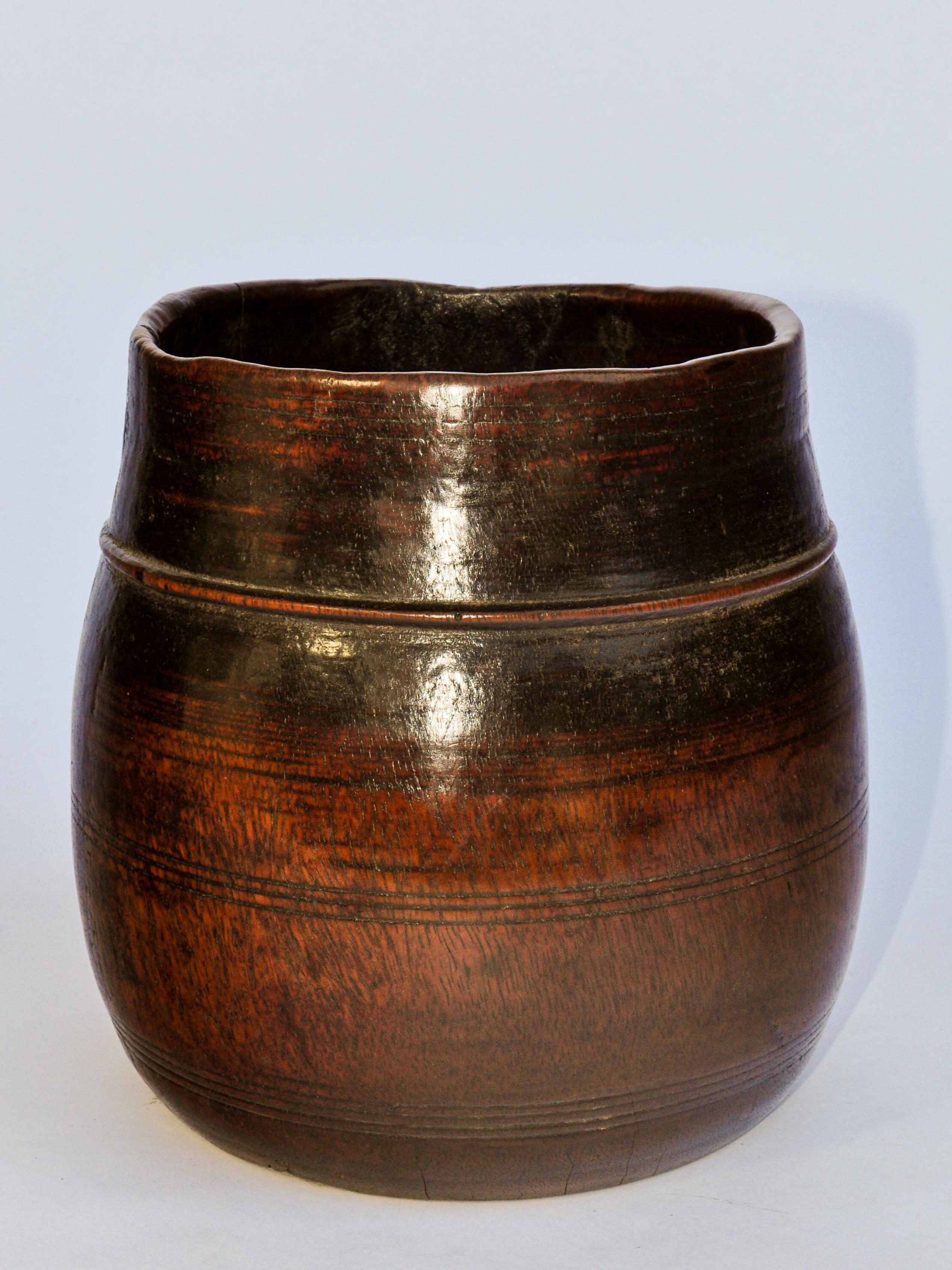 Vintage wooden grain measure pot from the Mountains of Nepal. Mid-20th century.
This handcrafted wooden pot is called a Pathi, the Nepali term denoting a standard unit of measure for grains and lentils. It comes from rural Nepal, and would have