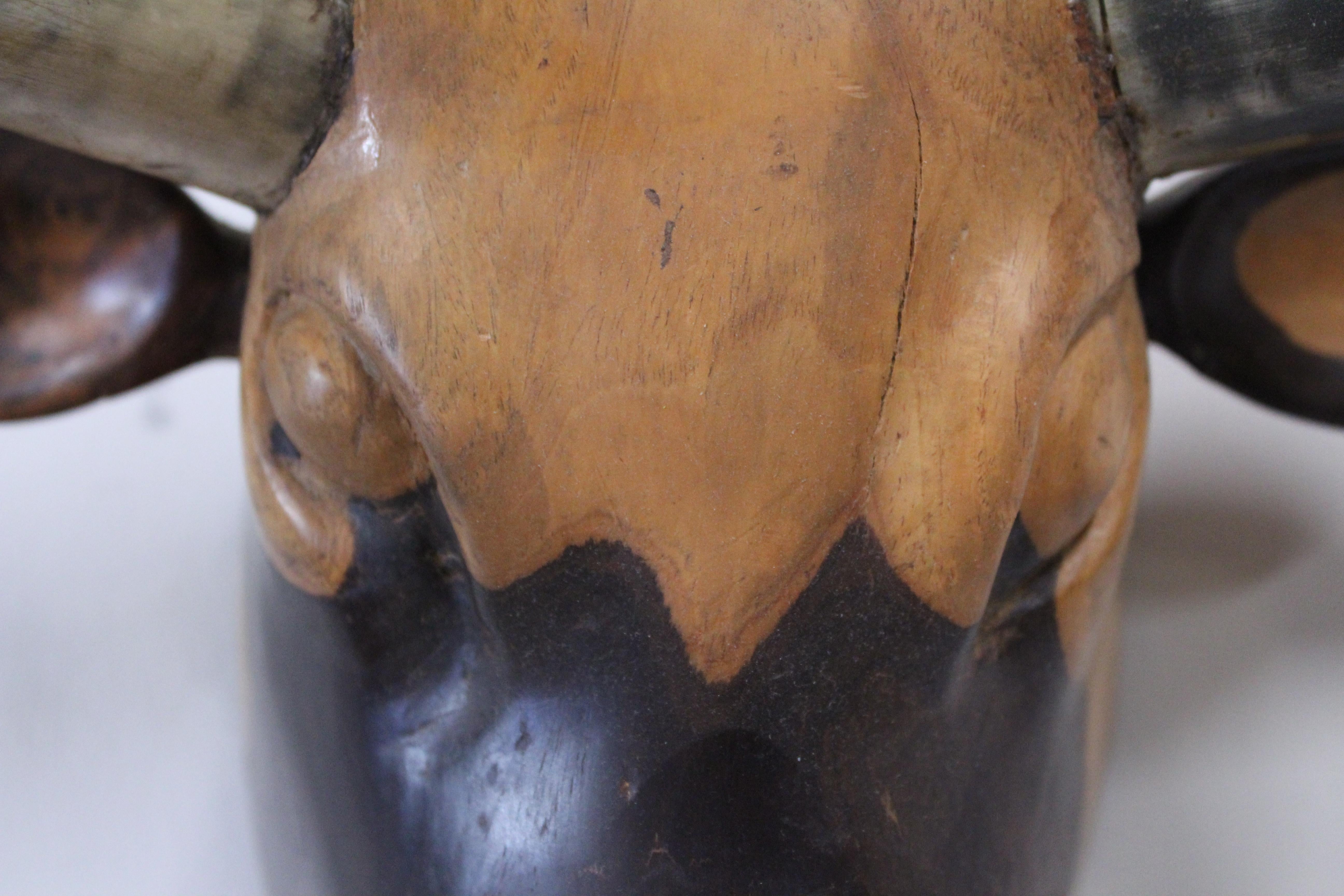 Vintage hand carved wooden bull's head is solid wood with real horns.