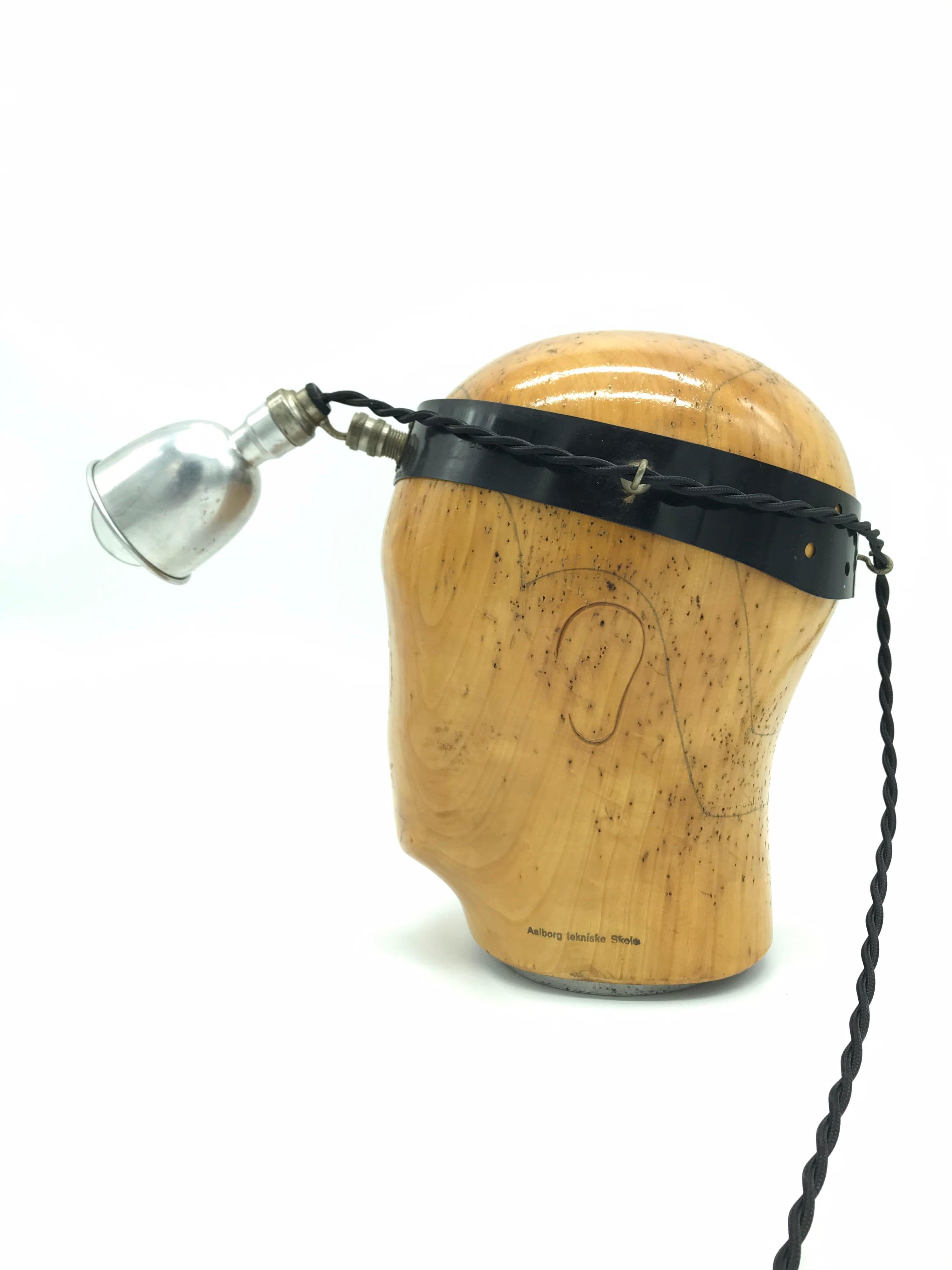 Vintage medical head stand table lamp.
Made from a vintage wooden hat or wig stand and mounted with an antique medical inspection lamp
A cool table lamp like no other
The medical lamp has a small 6cm aluminum pressed shade and with a carbon filament
