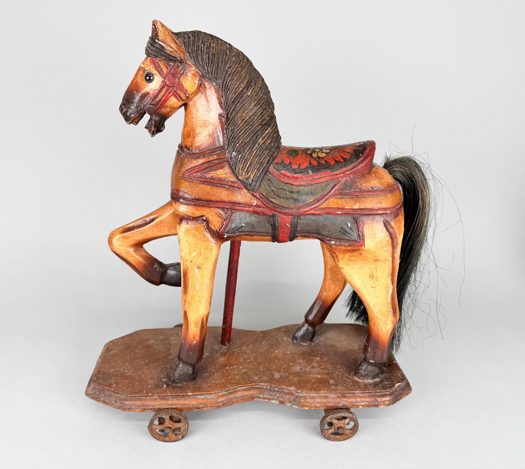 Vintage decoration or a toy. French wooden horse on wheels. Original condition.
