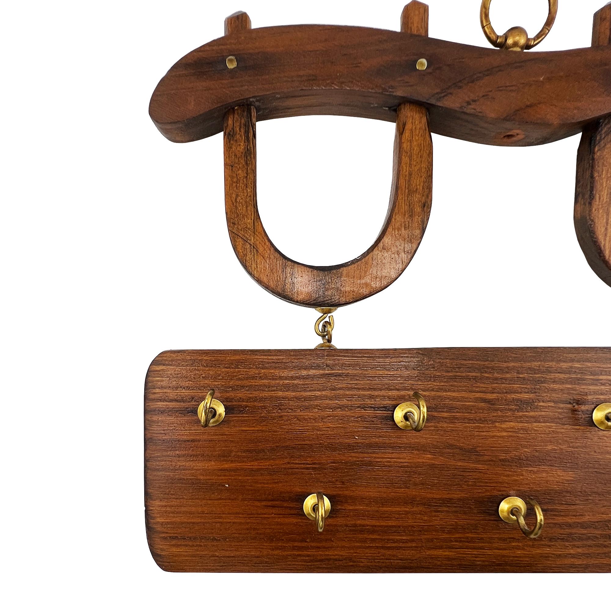Ein bezaubernder Schlüsselanhänger für Pferde, handgefertigt aus Massivholz und mit Messingbeschlägen versehen. Dieses rustikale Wandregal zeigt ein einzigartiges Doppelhufeisenmotiv, das Glück und Schutz symbolisiert. Es hängt über einem