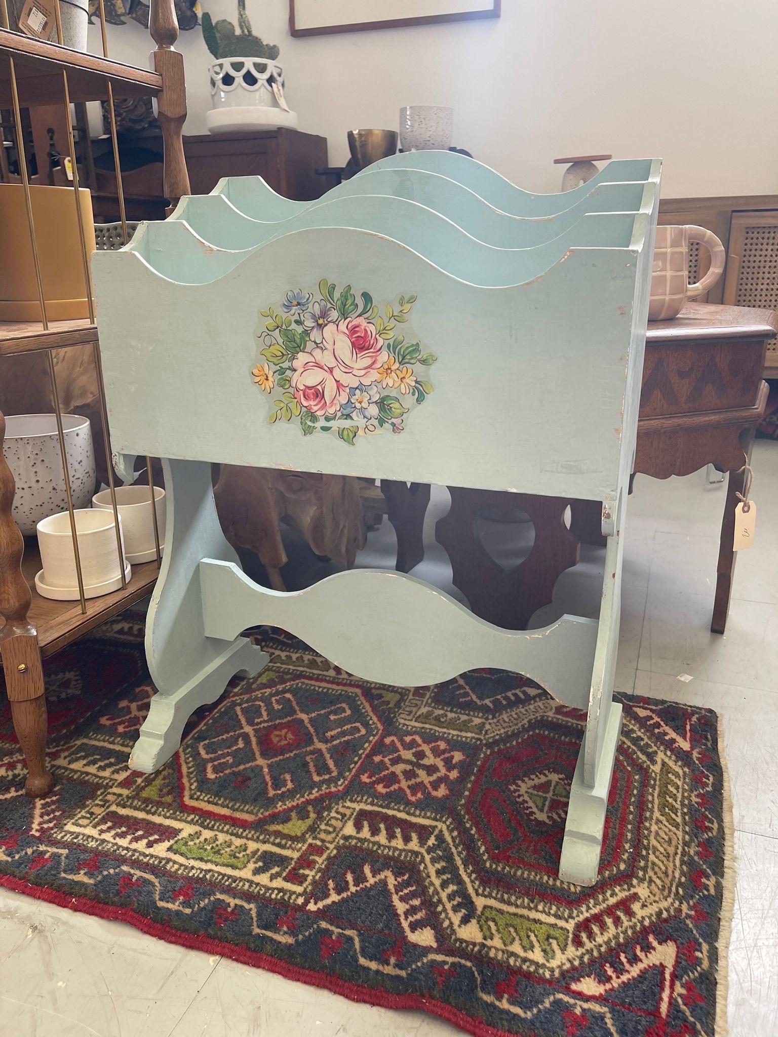 This Magazine rack has sculpted wood edges and a bright floral motif on the front. The Rack is split into three sections. Vintage Condition Consistent with Age as Pictured.

Dimensions. 20 W ; 10 D ; 27 H