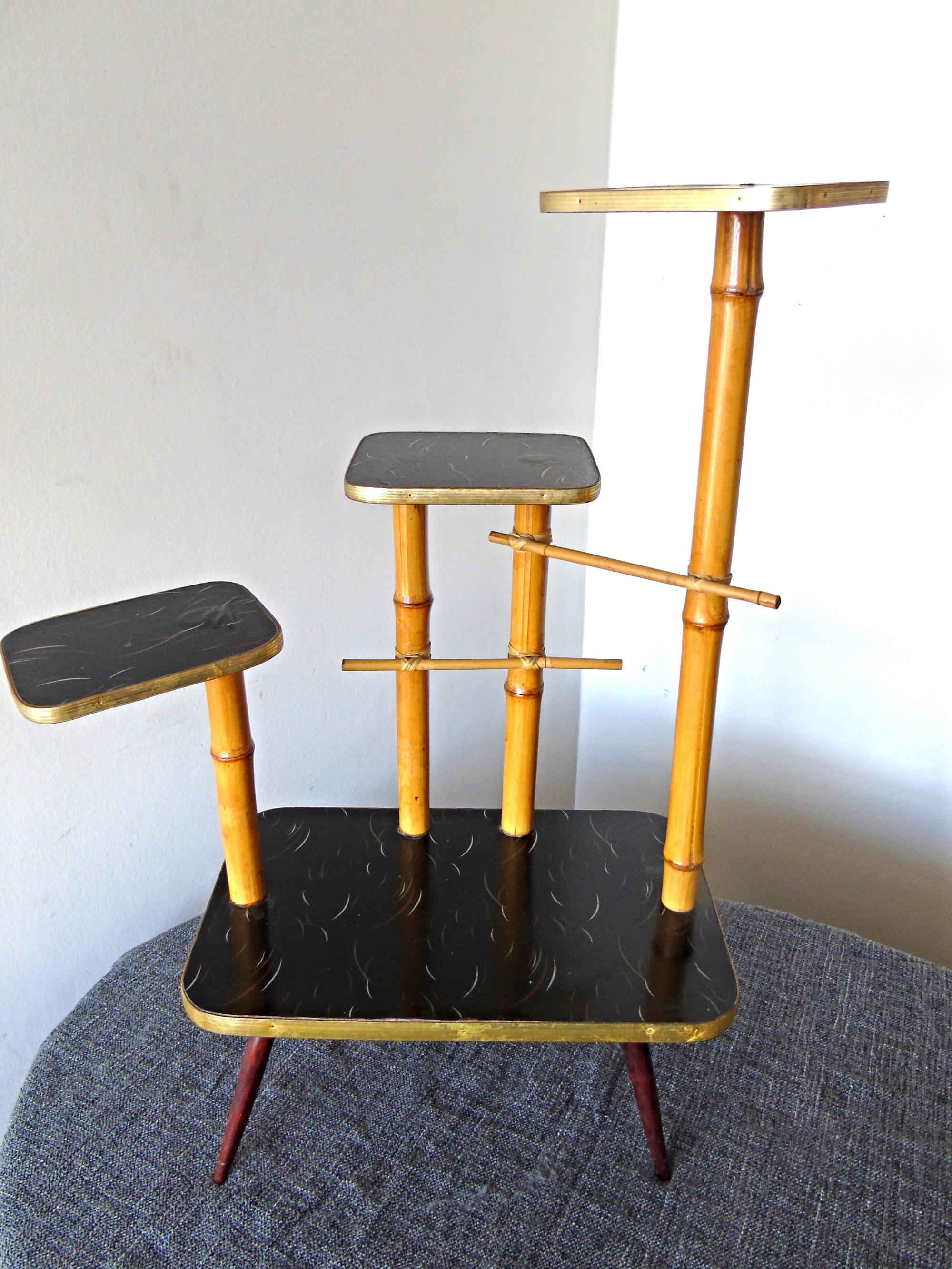 Vintage three-tiered plant stand made from bamboo with lacquered wooden plates and a brass finish.

Lovely vintage decorative piece.

Good condition.

Measures: H 31 inch 80cm
W 20 inch 52cm.



 