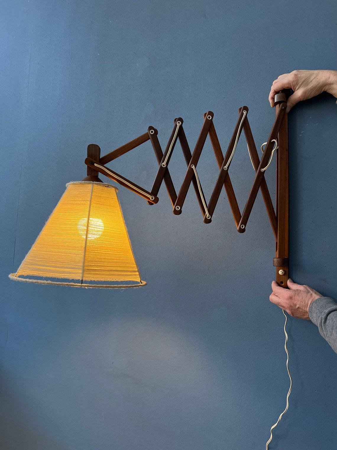 Lampe à ciseaux vintage en teck avec cadre en bois et abat-jour beige en forme de corde. Le mécanisme de ciseaux permet d'étendre la lampe à partir du mur. L'abat-jour lui-même est également réglable. La lampe nécessite une ampoule E27/26 (standard)