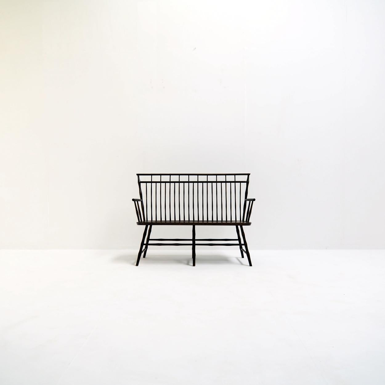 Vintage wooden spindle back settee in faux bamboo.

The bench probably dates from the 1970s and is in good vintage condition with some wear and tear on the seat.

The bench is solid and firm nevertheless it needs to be treatened with some care.